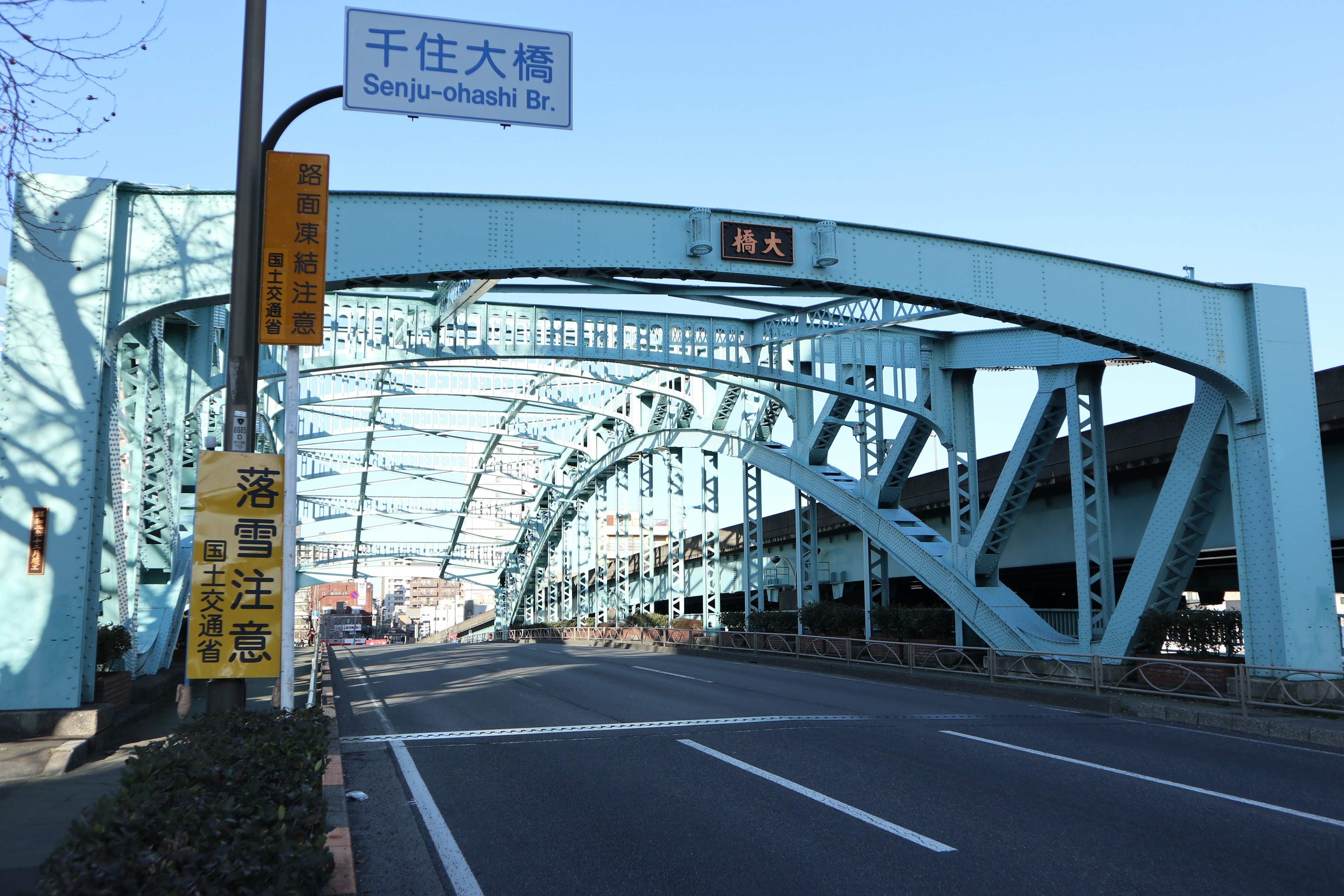 Blue arch bridge with an open road beneath