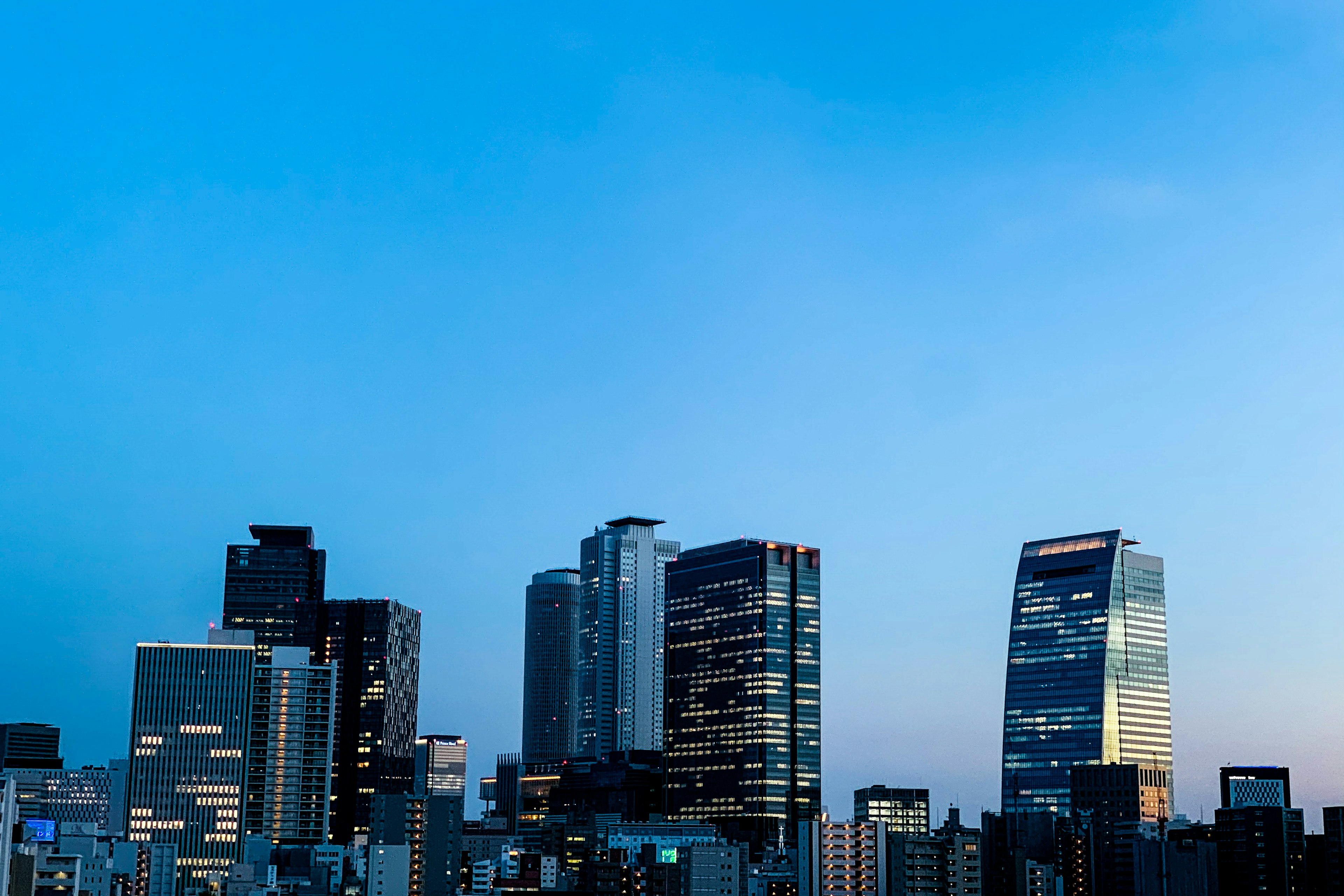 Silhouette of modern skyscrapers against a blue sky