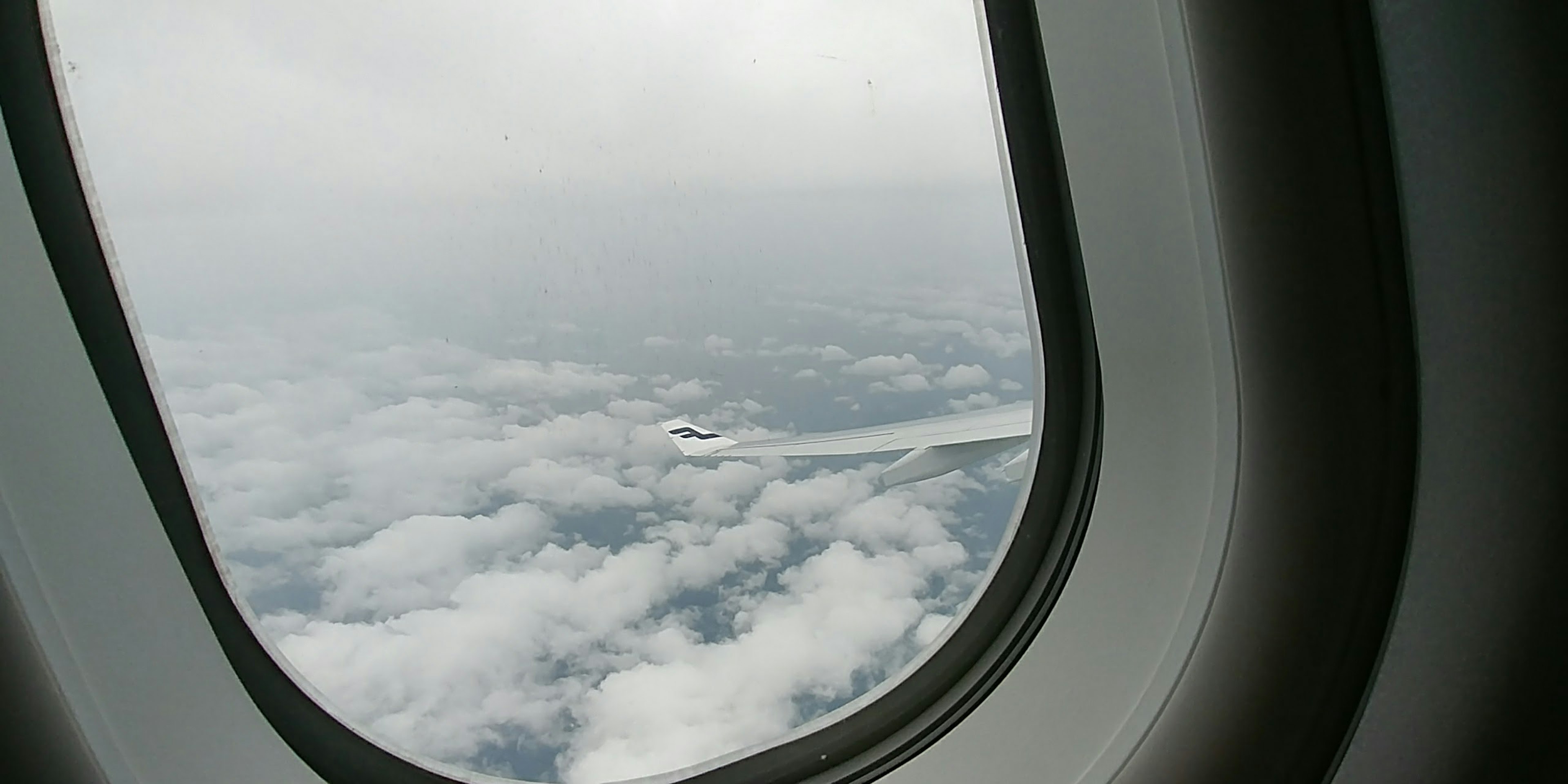 飛行機の窓からの曇り空と雲の景色