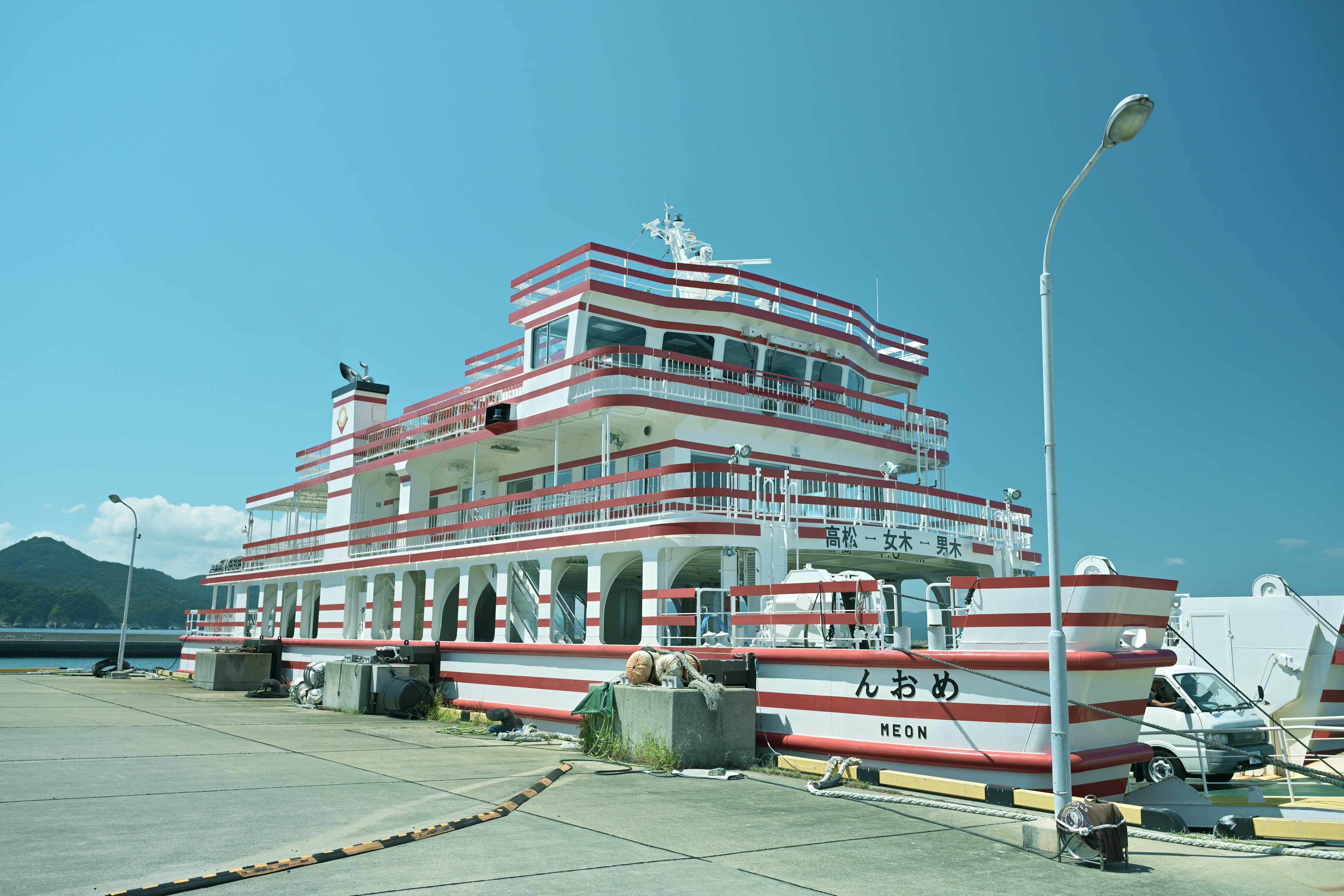 A boat with red and white stripes docked at a port