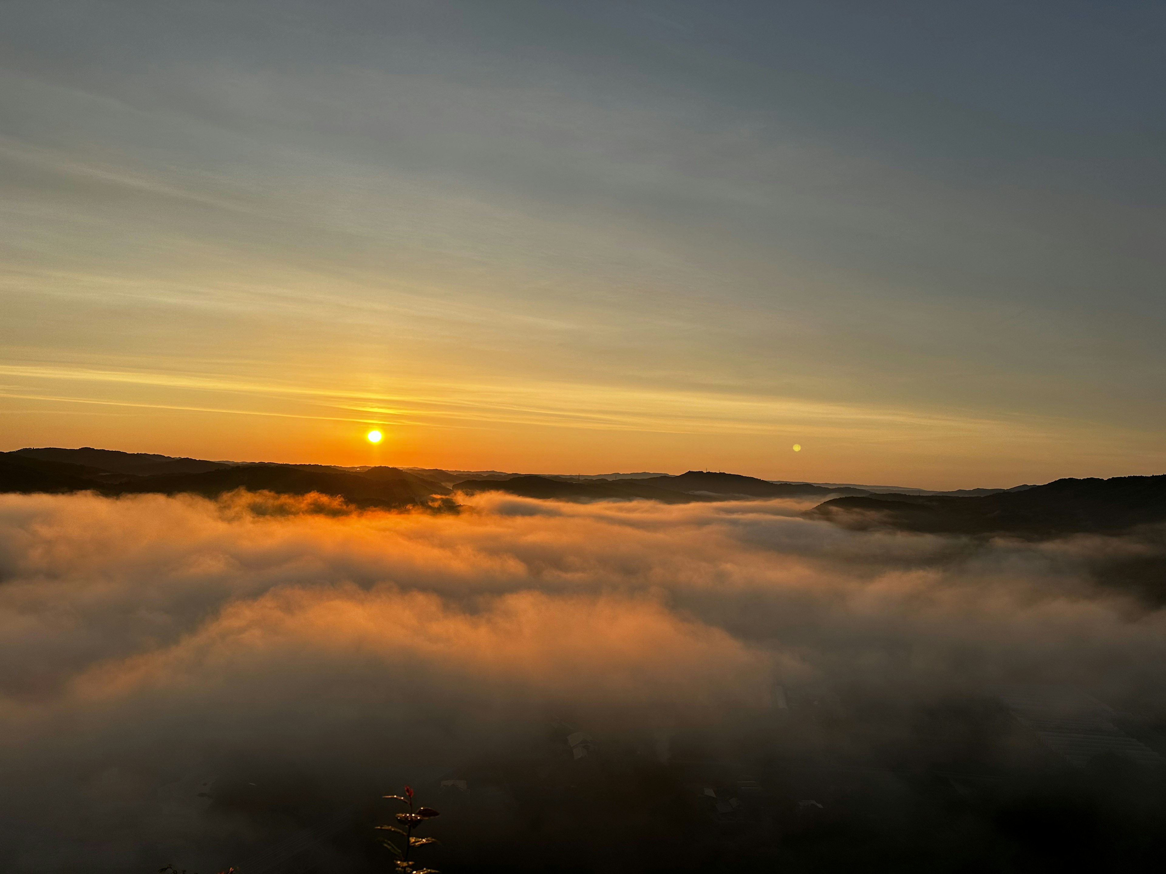 Beautiful landscape of the sun rising over a fog-covered valley