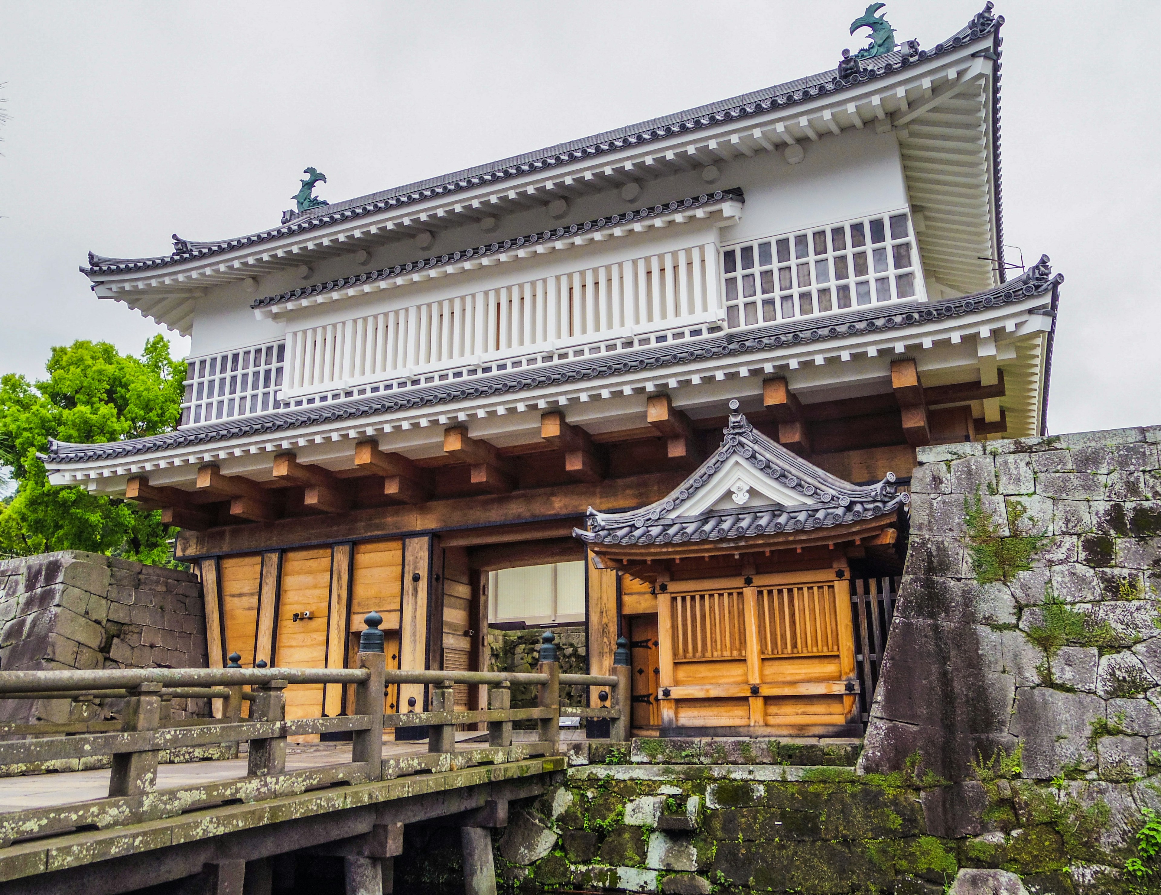 Schönes traditionelles japanisches Gebäude mit Holzbrücke und Steinmauern