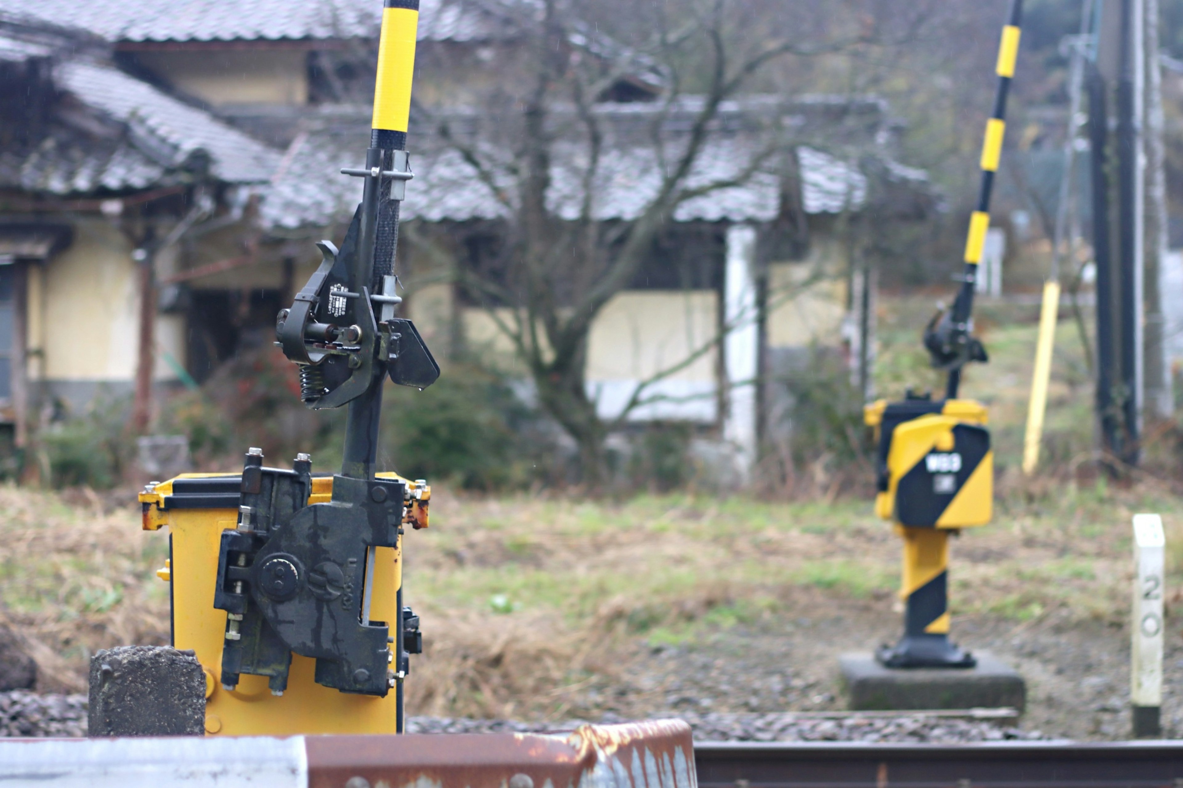 Segnali ferroviari gialli e neri in un contesto rurale