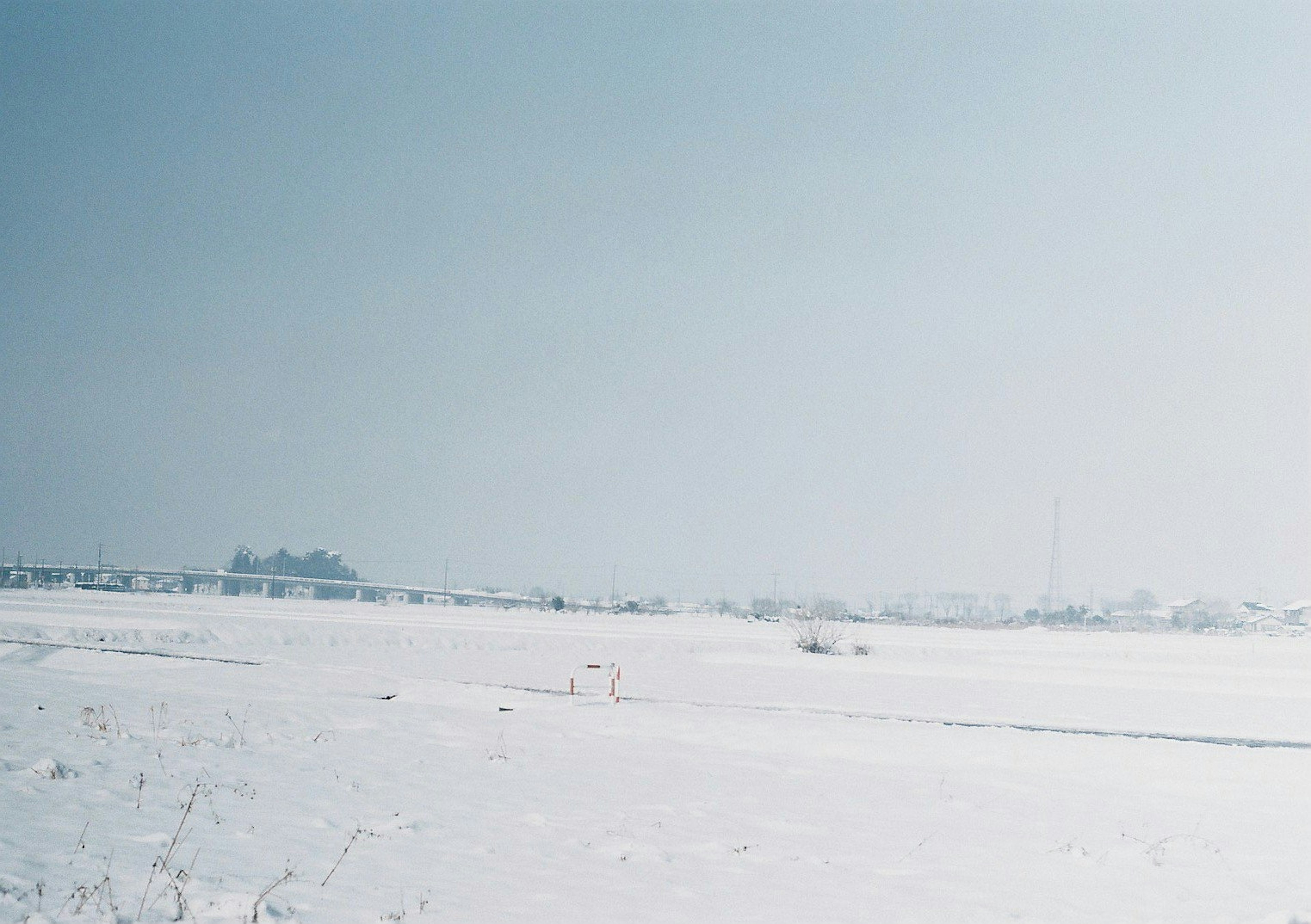 Vast snowy landscape with a pale blue sky