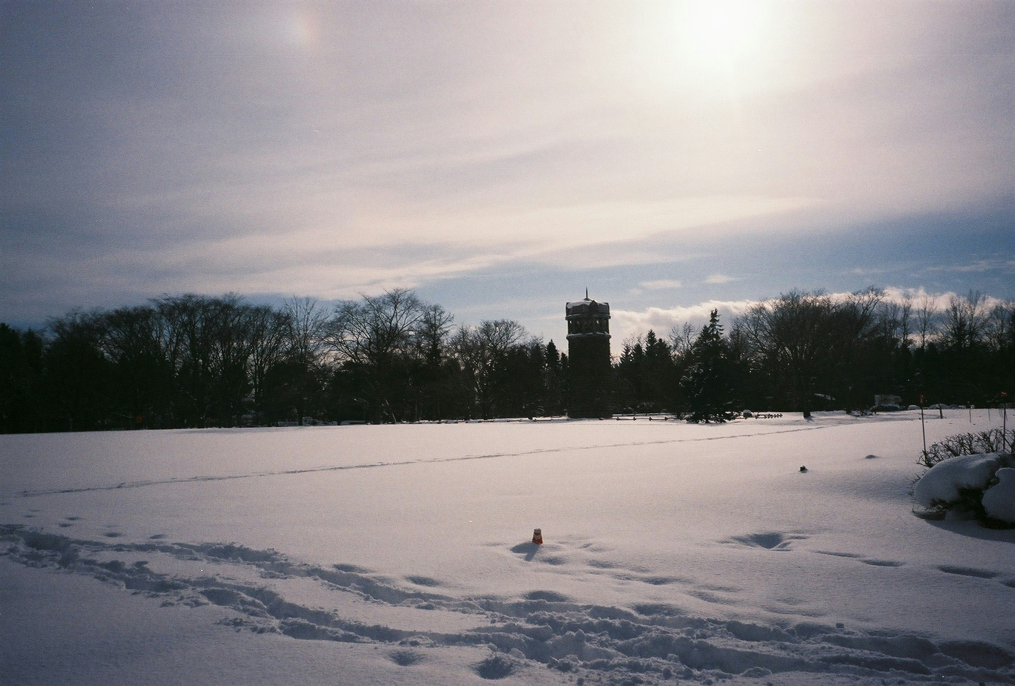 Snow-covered landscape with a distant tower