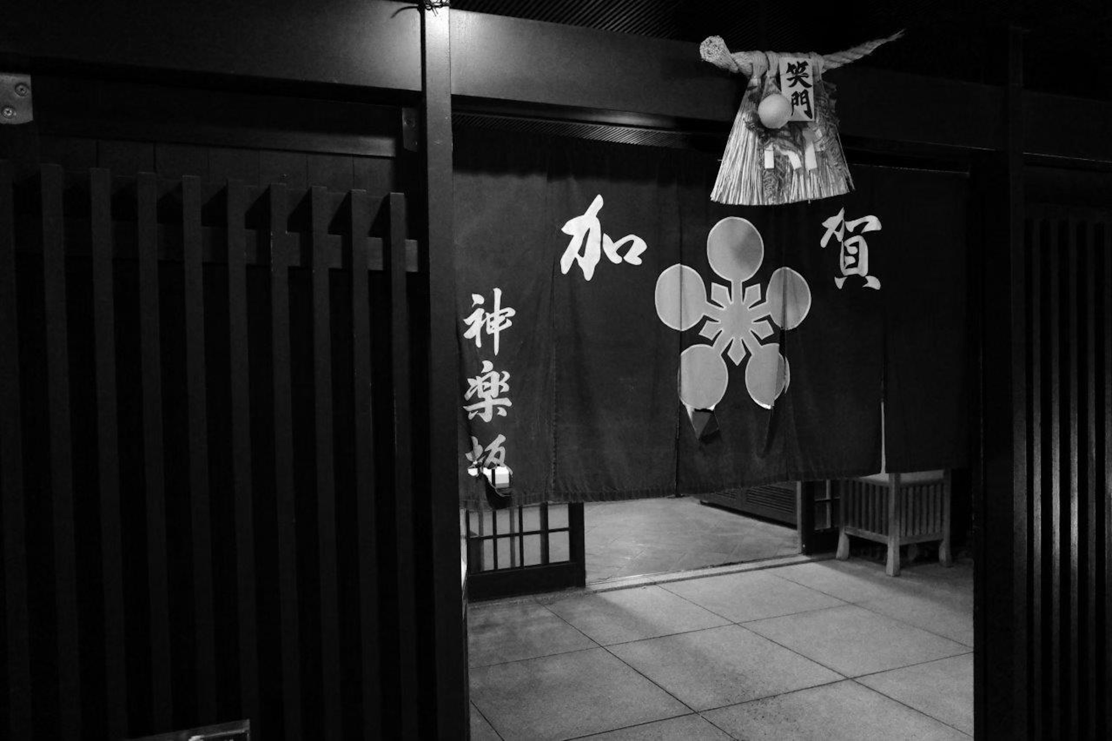 Traditional Japanese entrance in black and white featuring shrine decorations with the characters for Waga