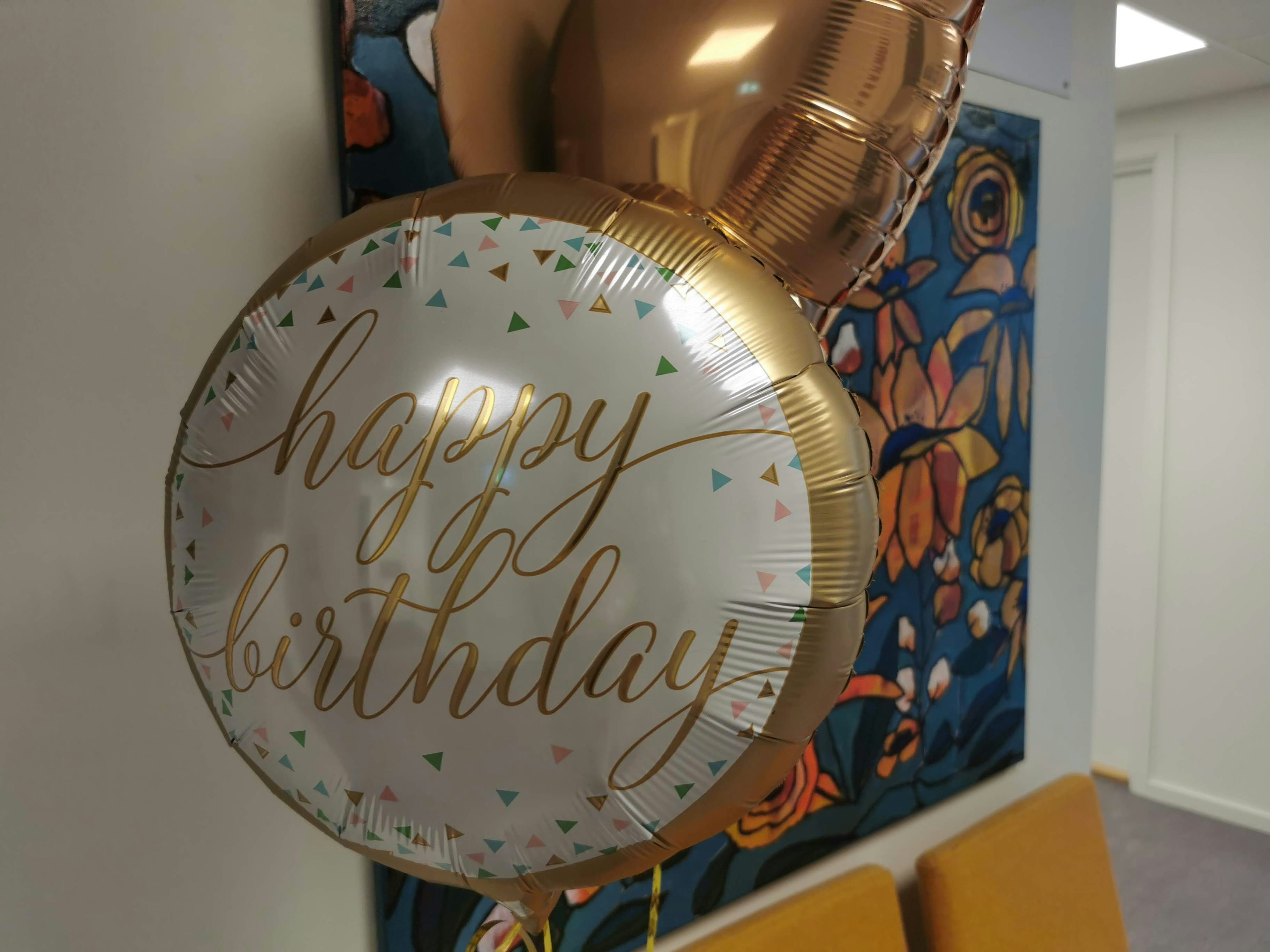 Ein Geburtstagsballon mit der Aufschrift alles Gute zum Geburtstag und einem bunten Hintergrund