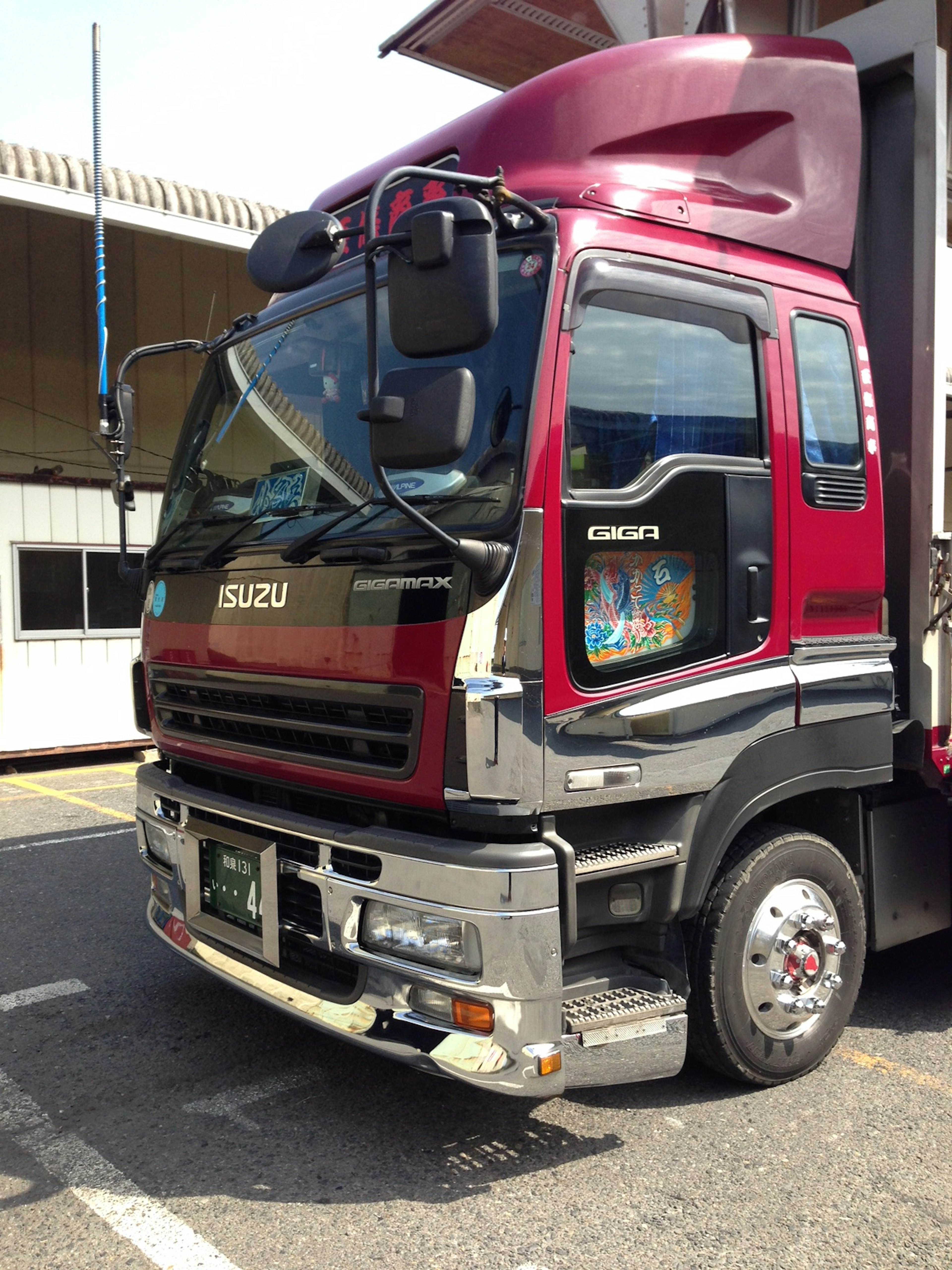 Camión Isuzu con cabina roja estacionado