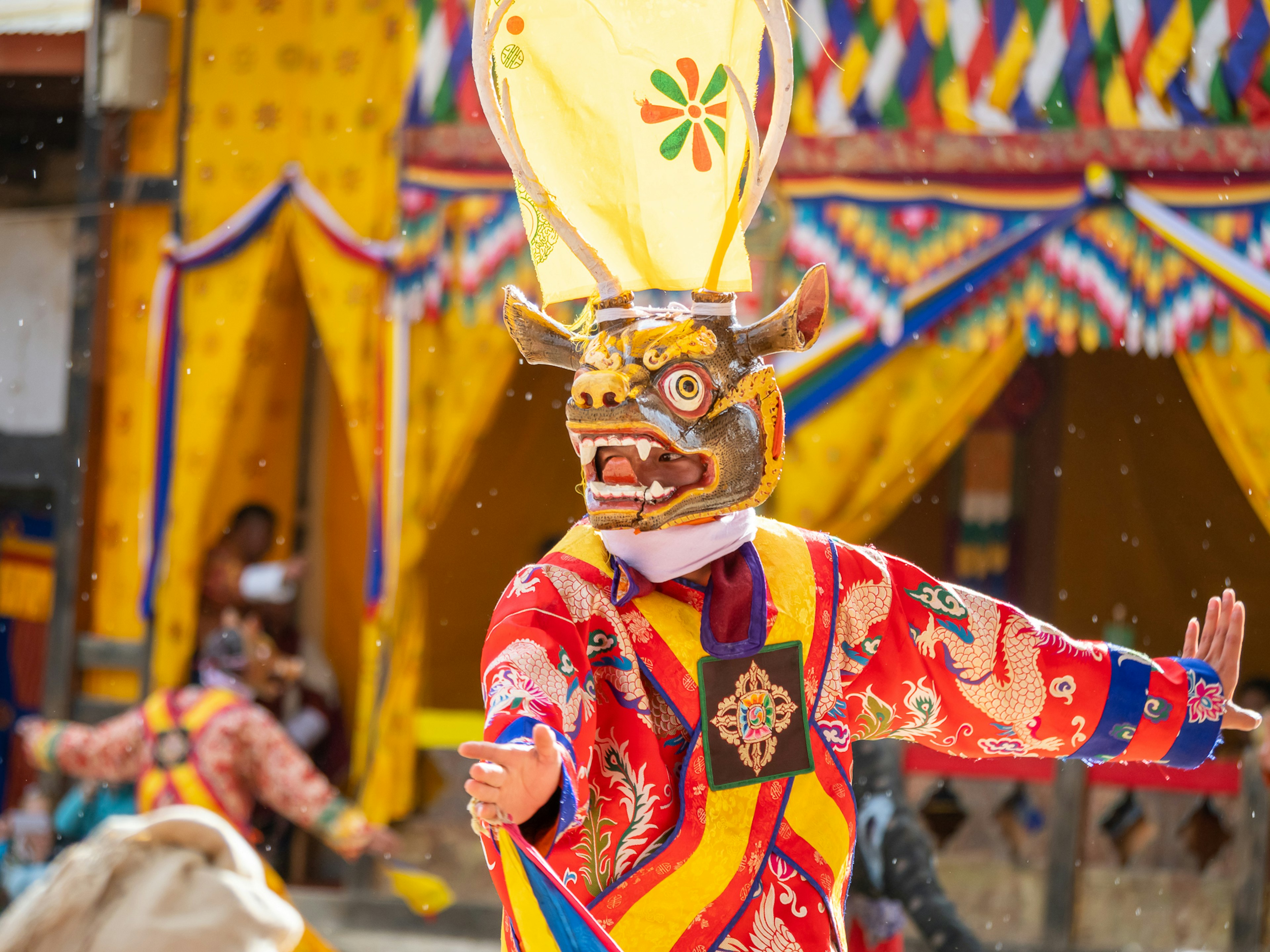 화려한 의상을 입은 가면 무용수가 축제에서 공연하고 있는 모습