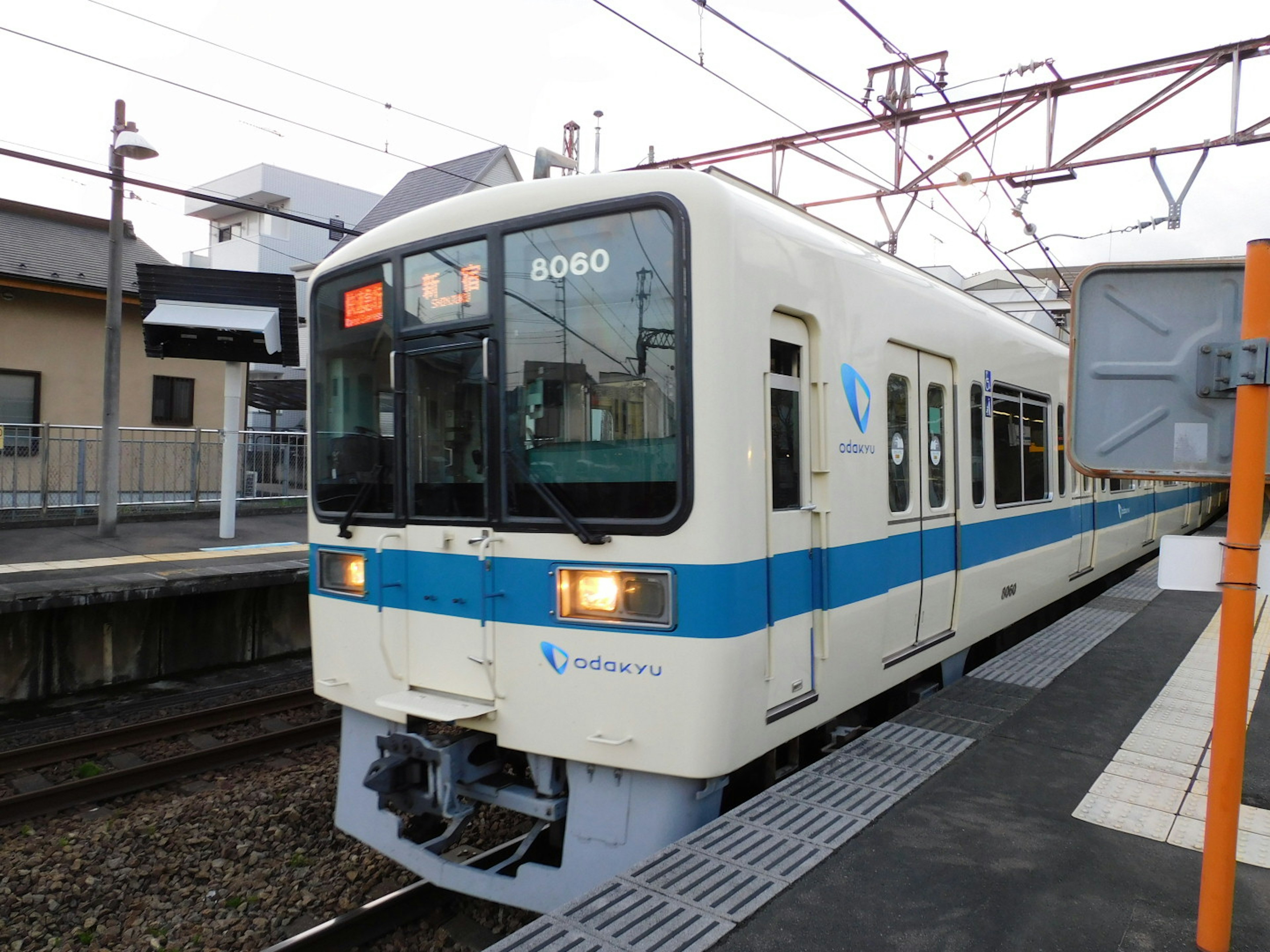 Kereta putih dan biru berhenti di stasiun