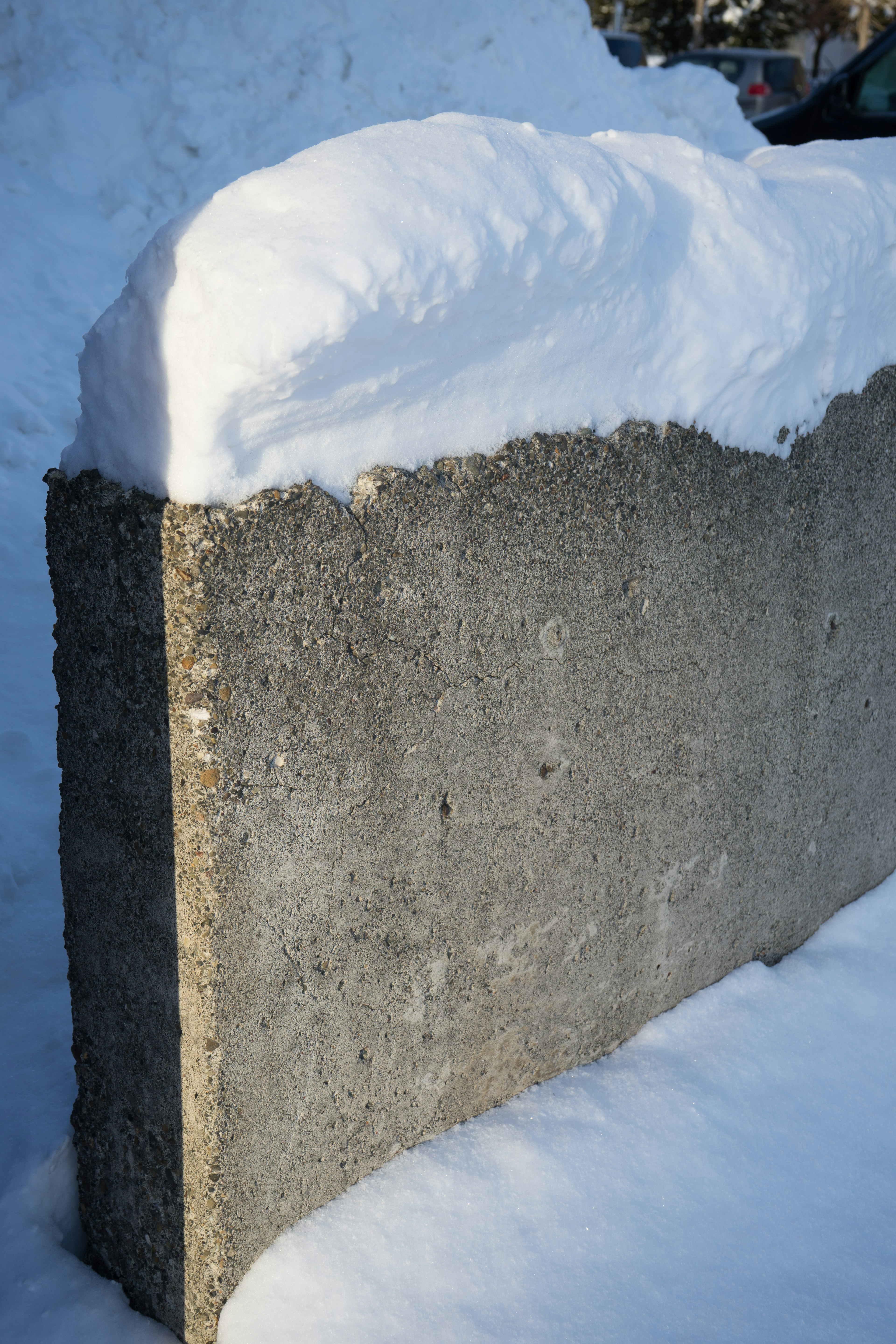 Parte di un muro di cemento coperta di neve