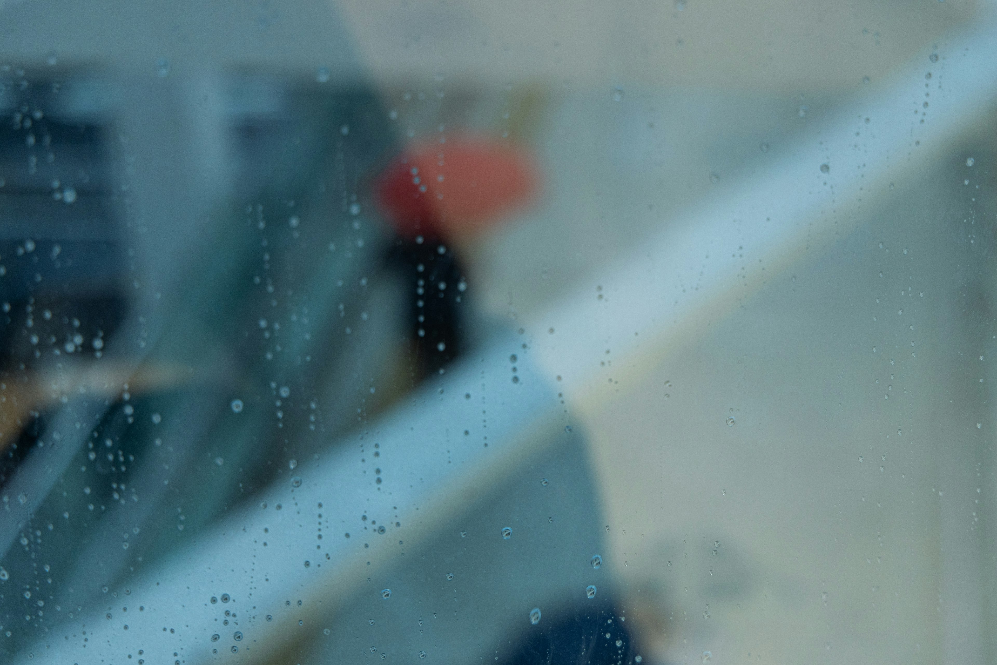 Blurred figure behind a foggy window with raindrops