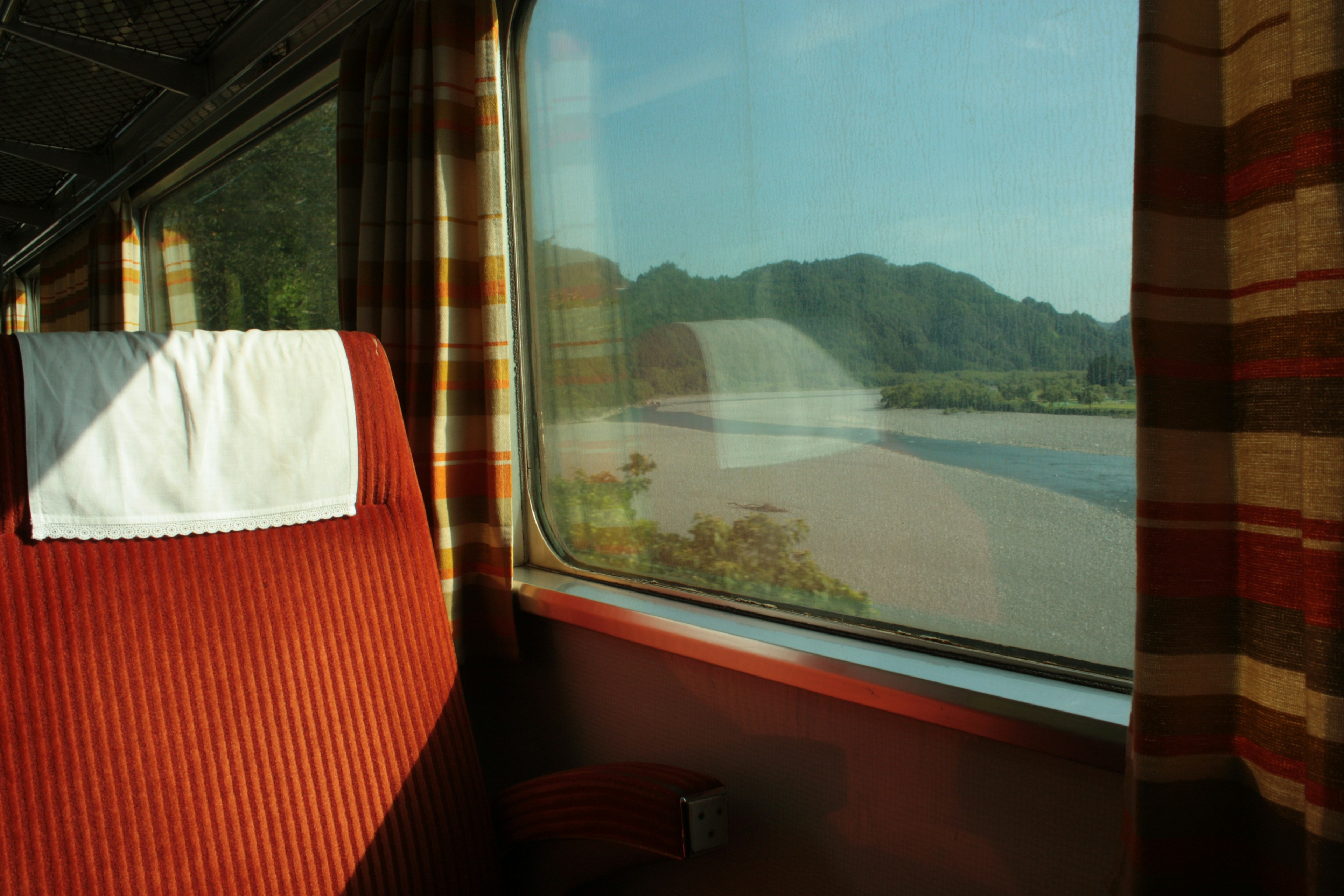 Intérieur de train avec siège rouge et vue panoramique par la fenêtre