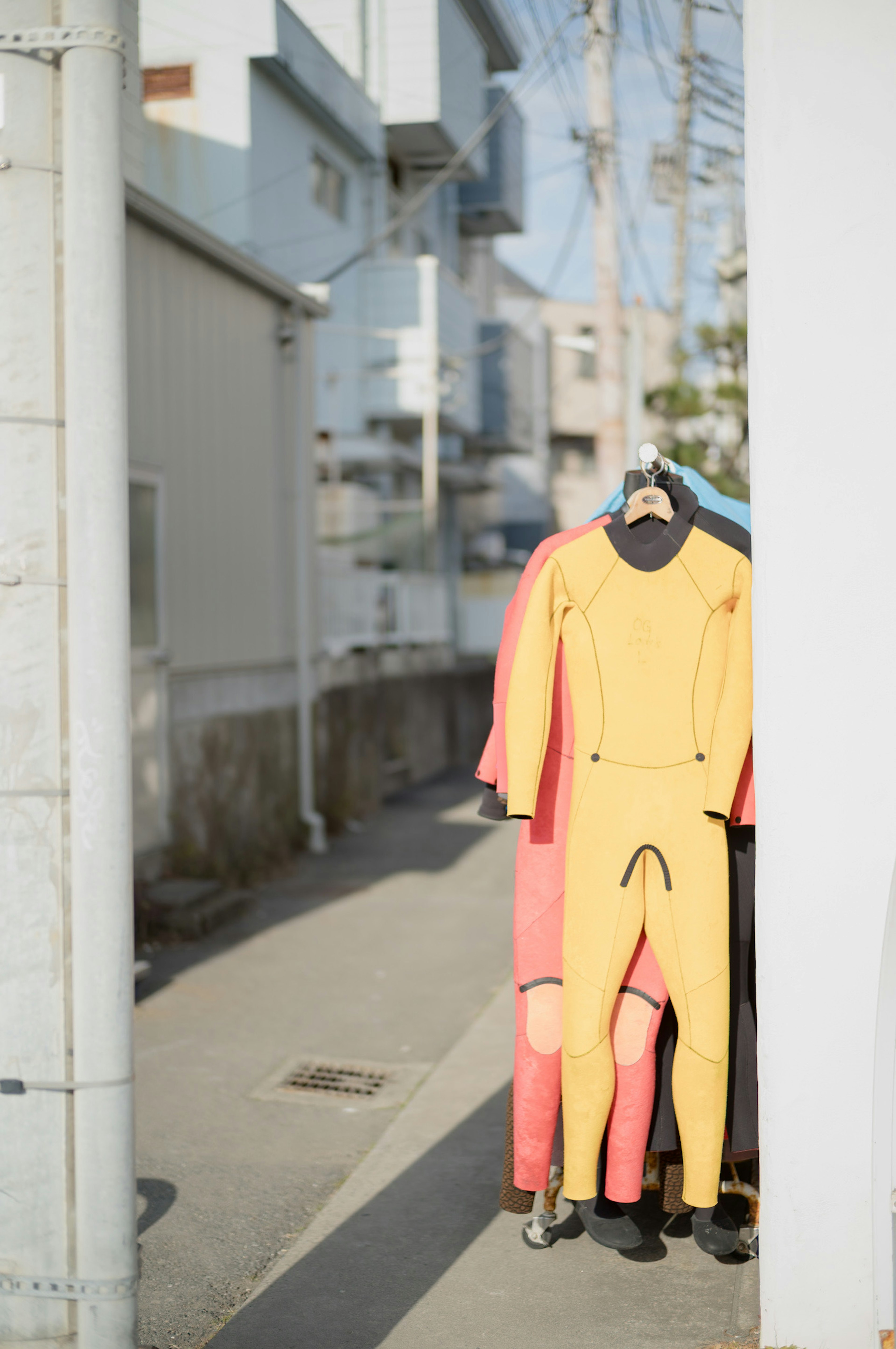 Combinaisons de plongée colorées accrochées dans une ruelle étroite