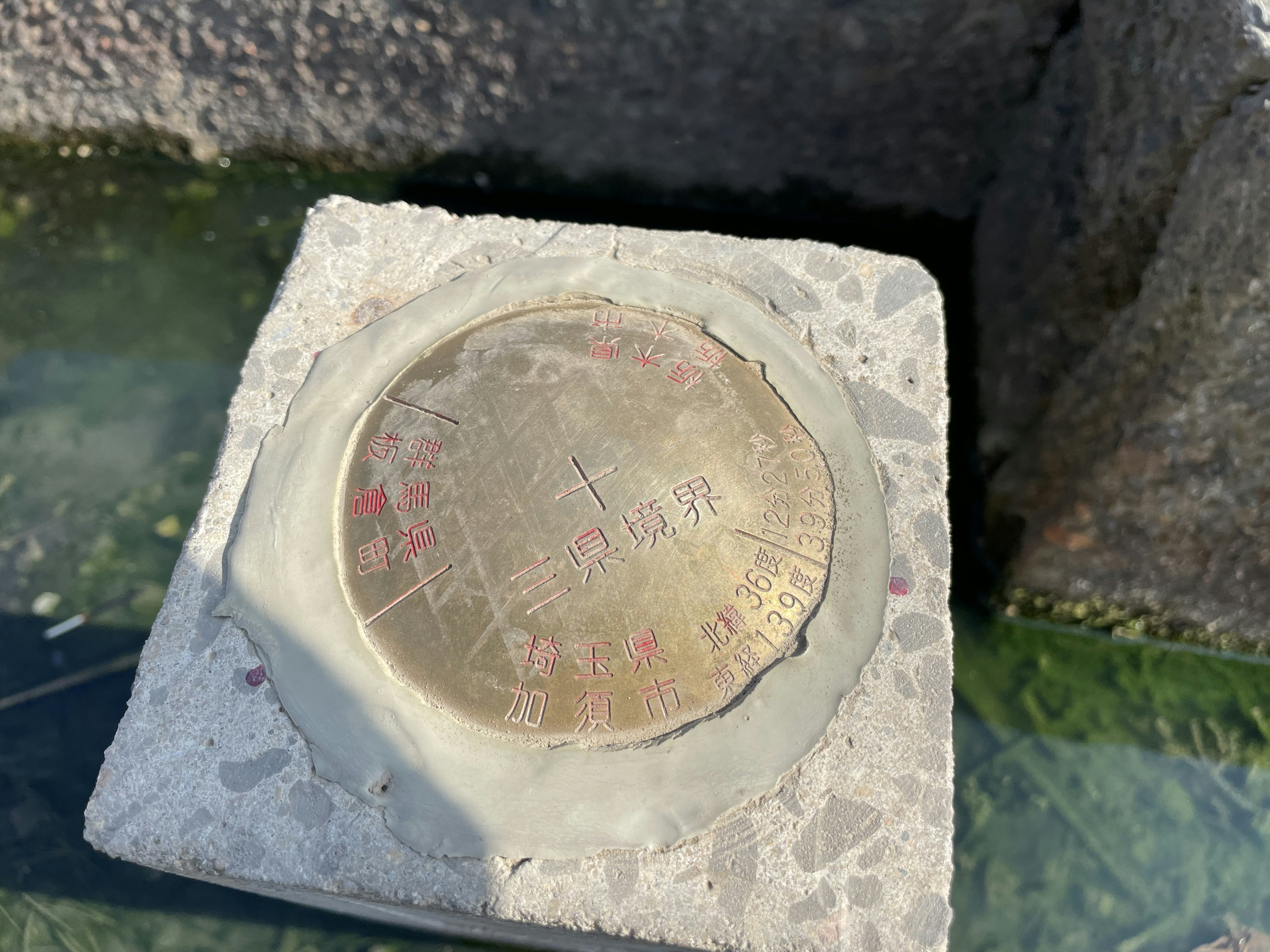 Une plaque circulaire en métal posée sur un bloc de ciment