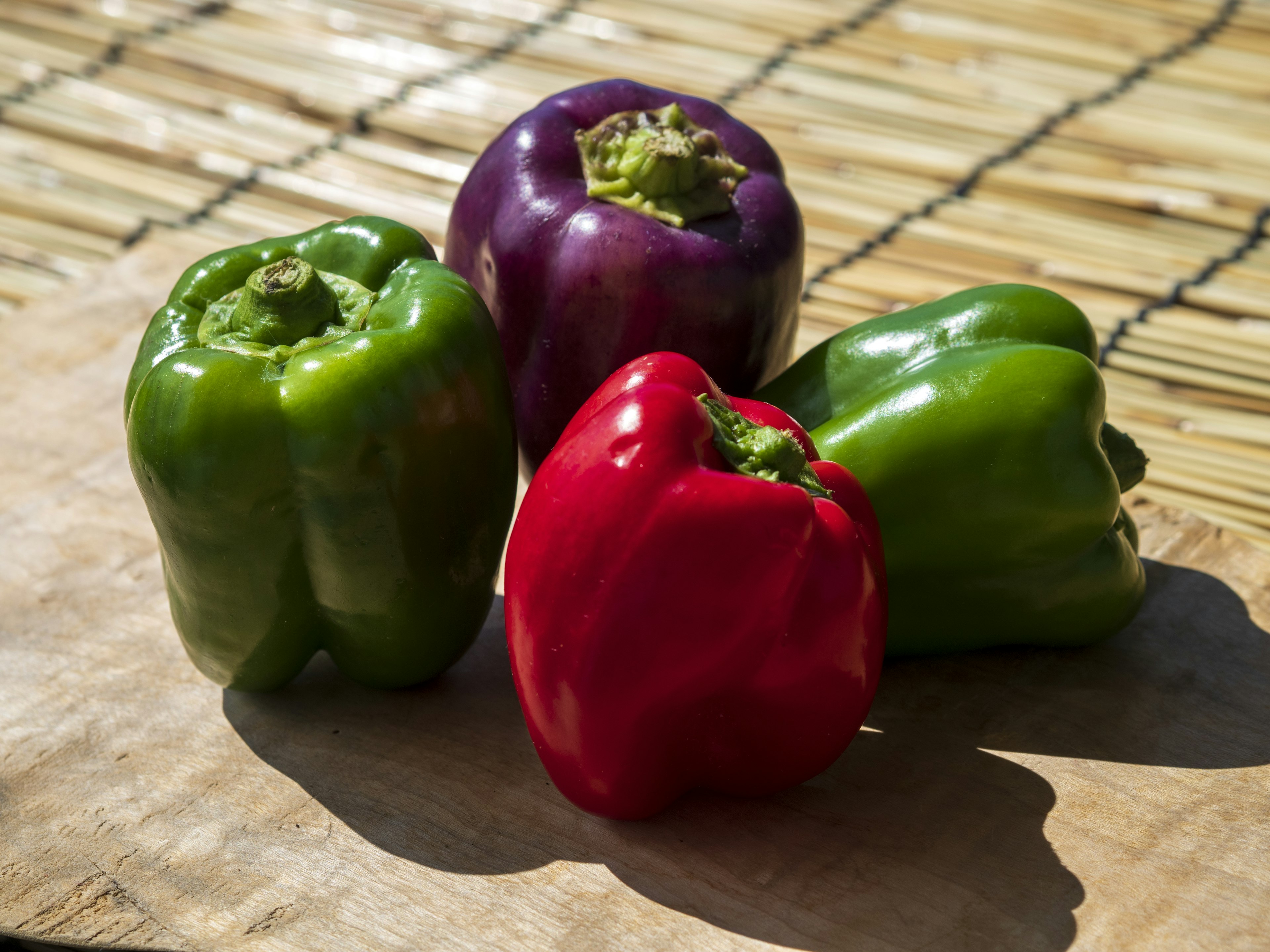 Colorful bell peppers arranged on a wooden surface