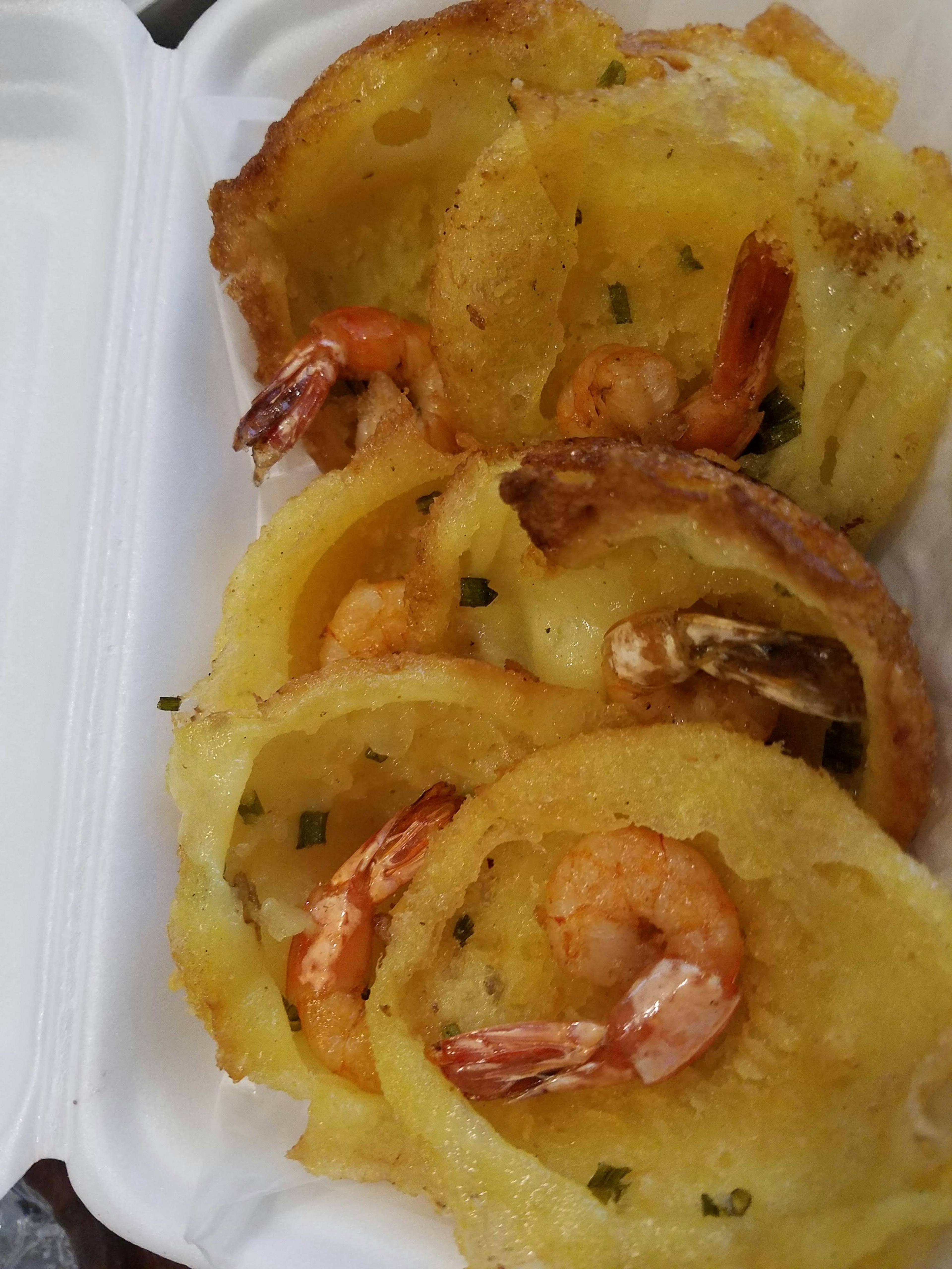 Plat de crevettes et de pommes de terre rissolées servi dans un récipient blanc