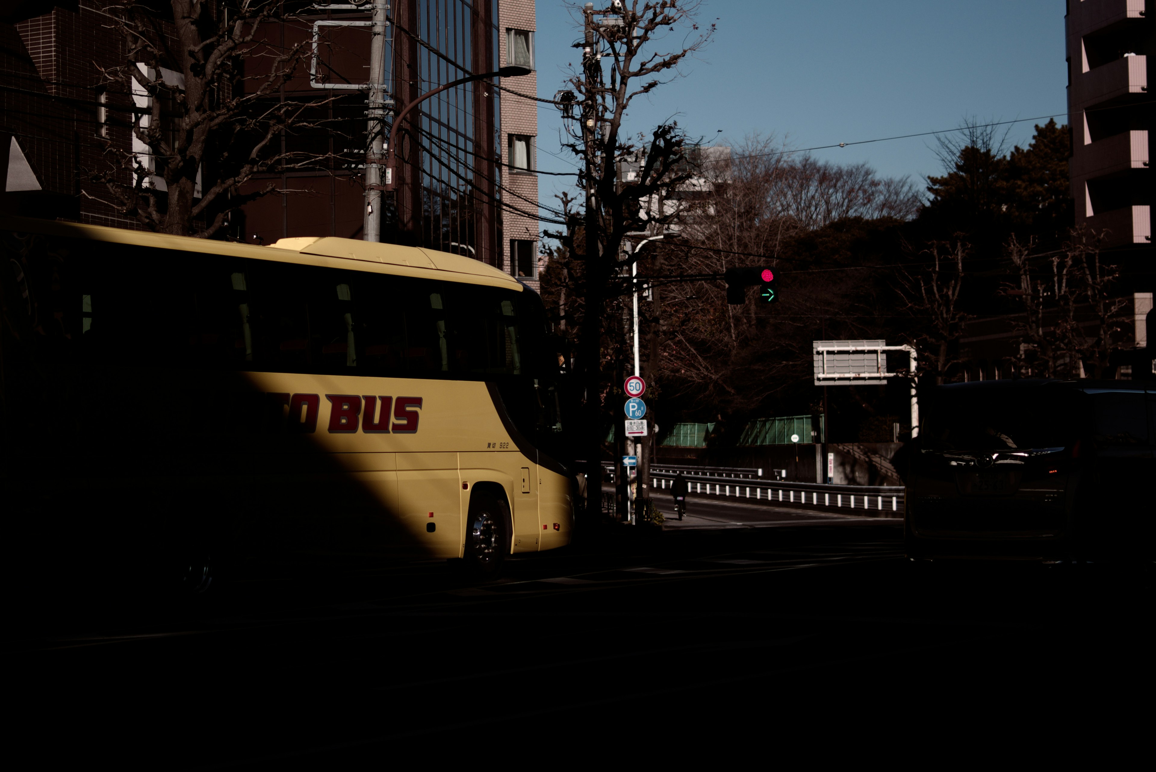 Gelber Bus an einer dunklen Straßenecke mit Ampel gestoppt