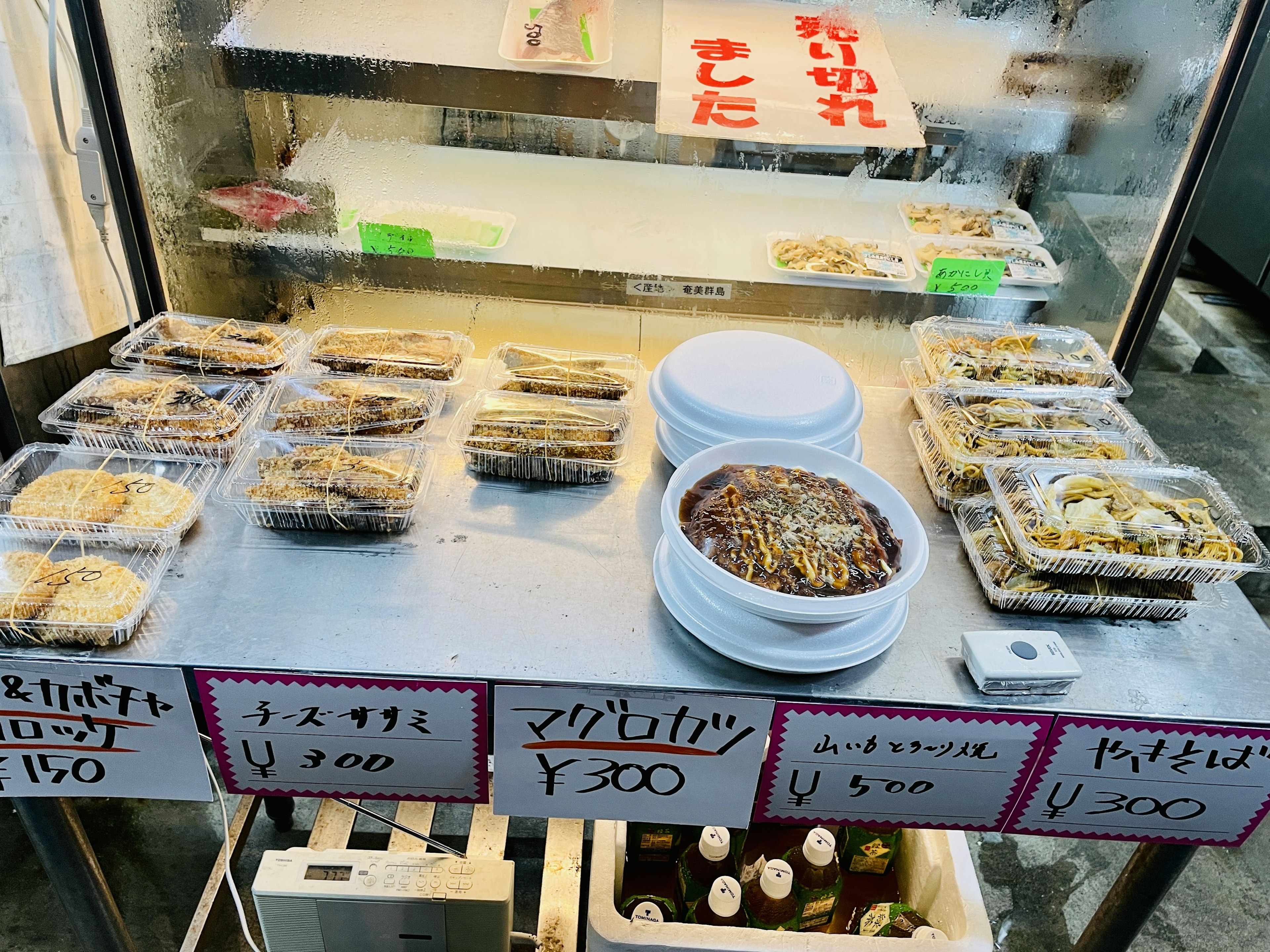 Japanese deli food displayed on a table with price tags