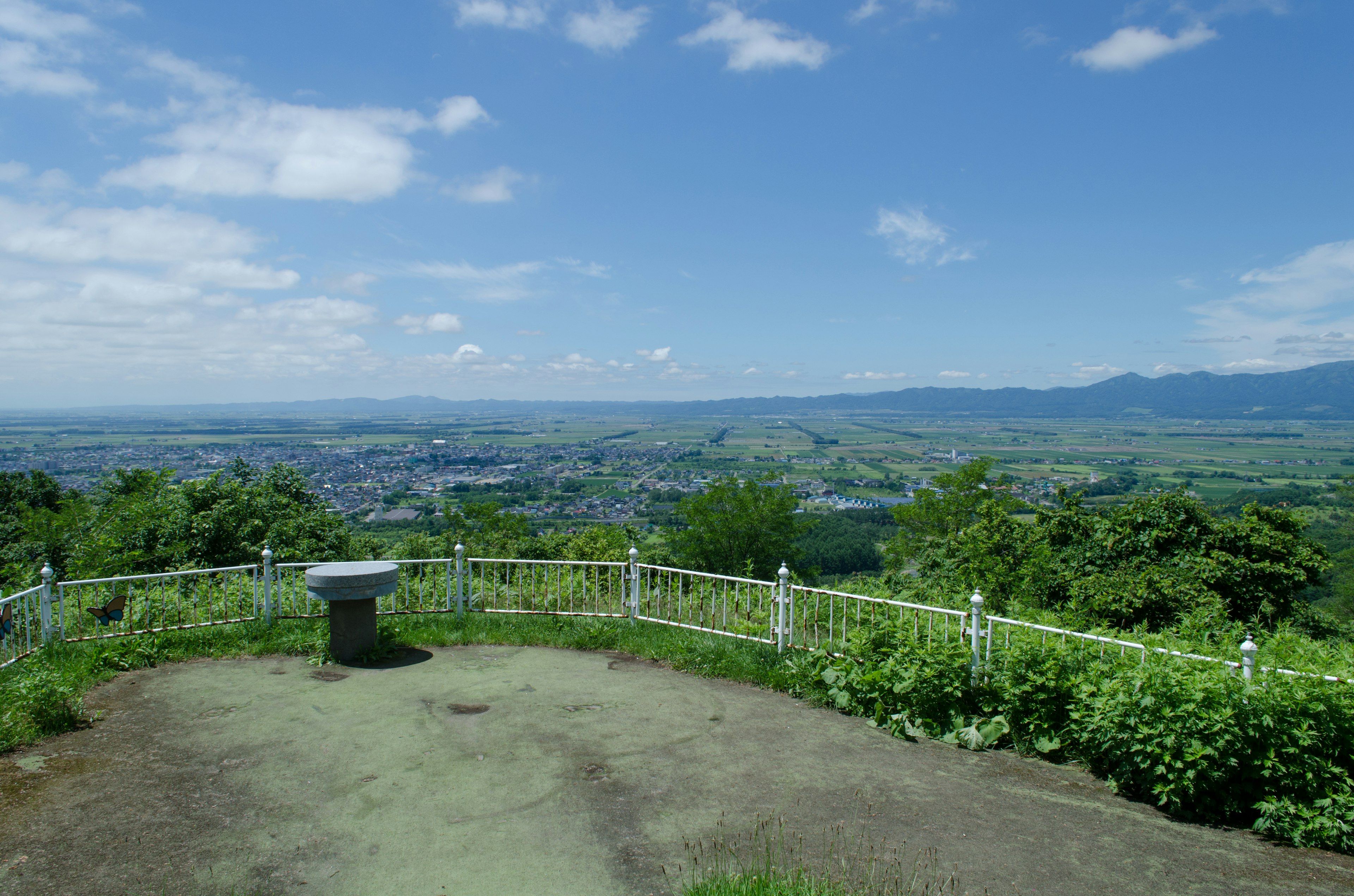 Vue panoramique depuis un belvédère avec ciel bleu et verdure luxuriante