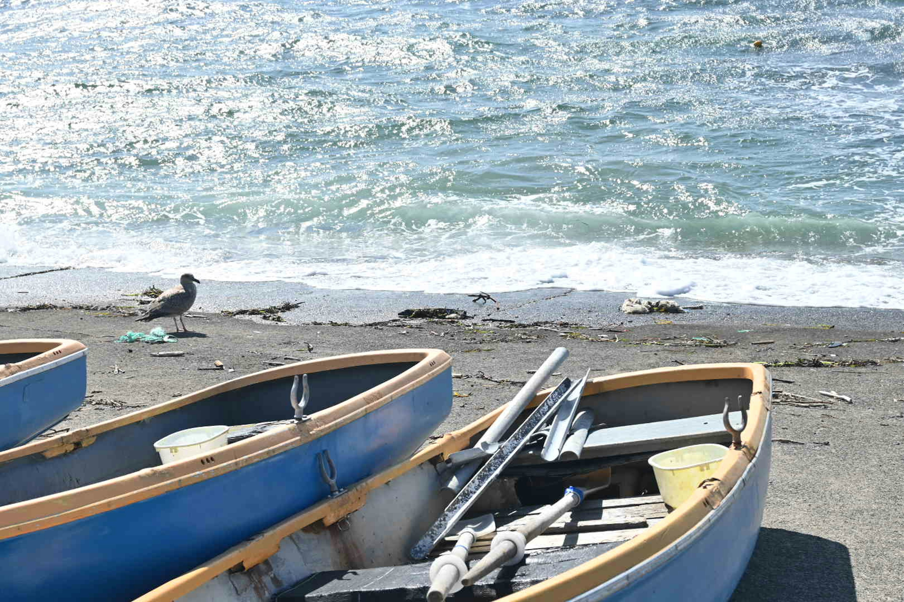 浜辺に並ぶ小型ボートと波のある海