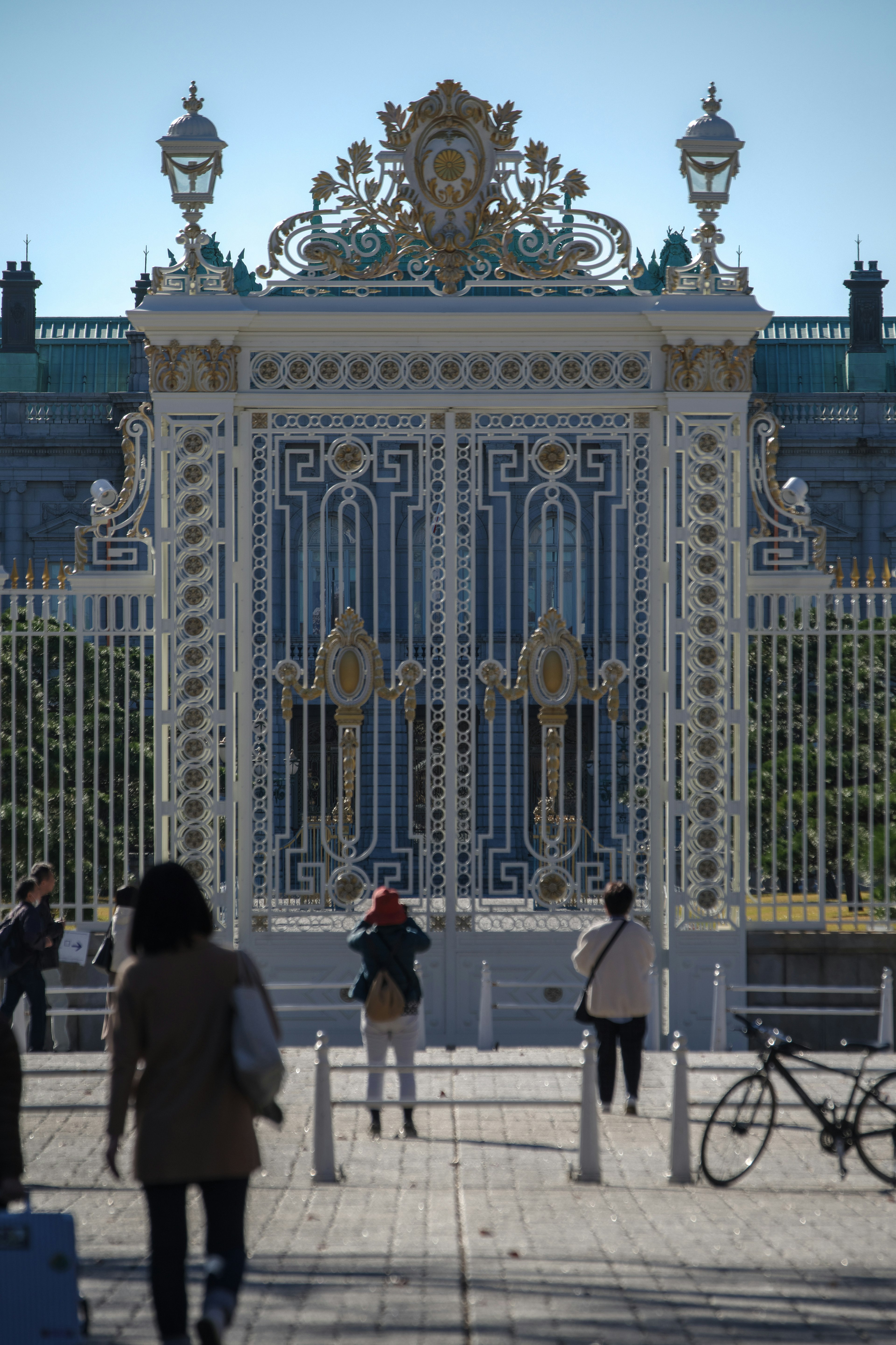 Elegant white gate with intricate decorations and visitors