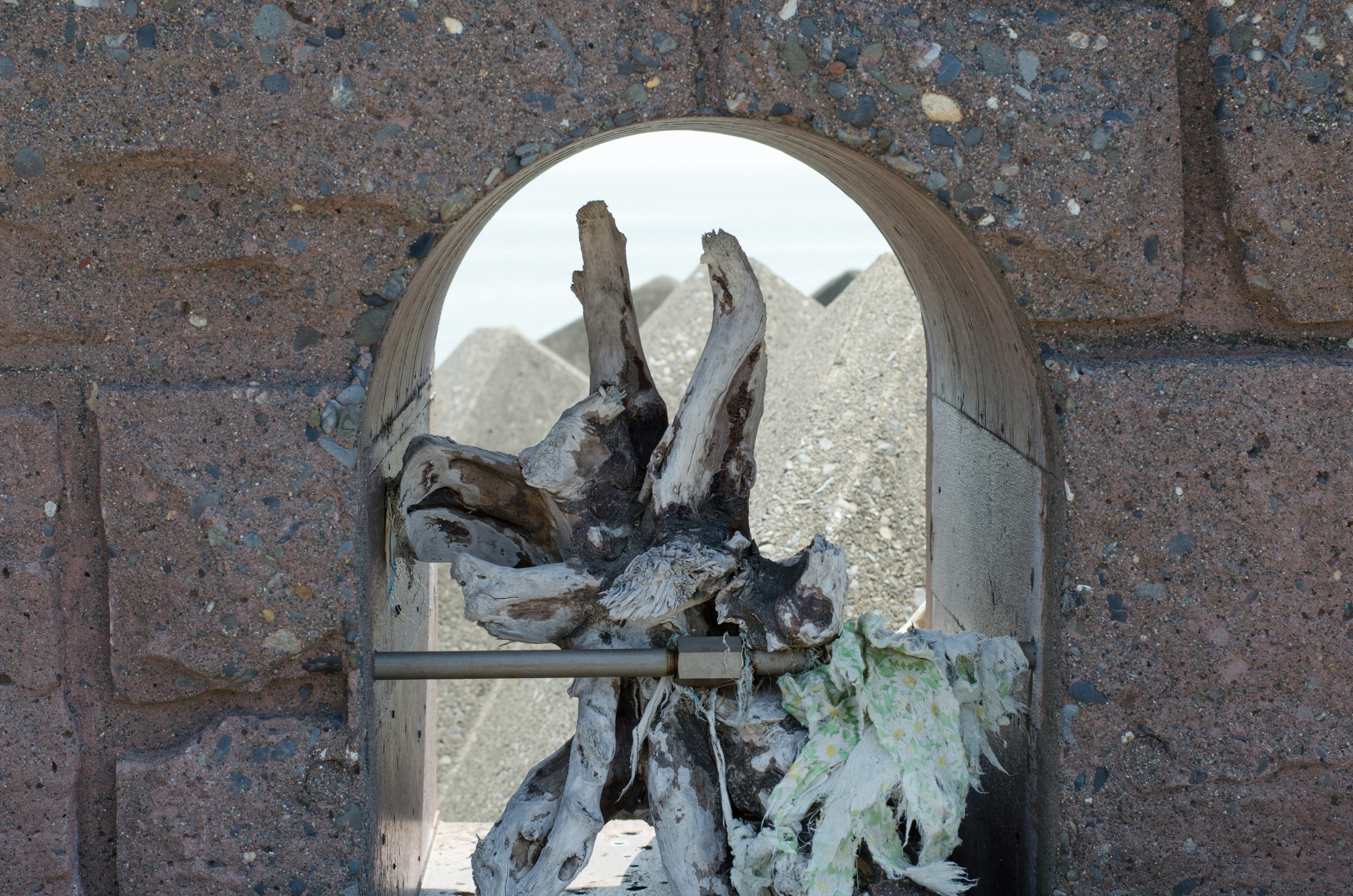 Sculpture en bois vue à travers une fenêtre en arc avec des montagnes en arrière-plan