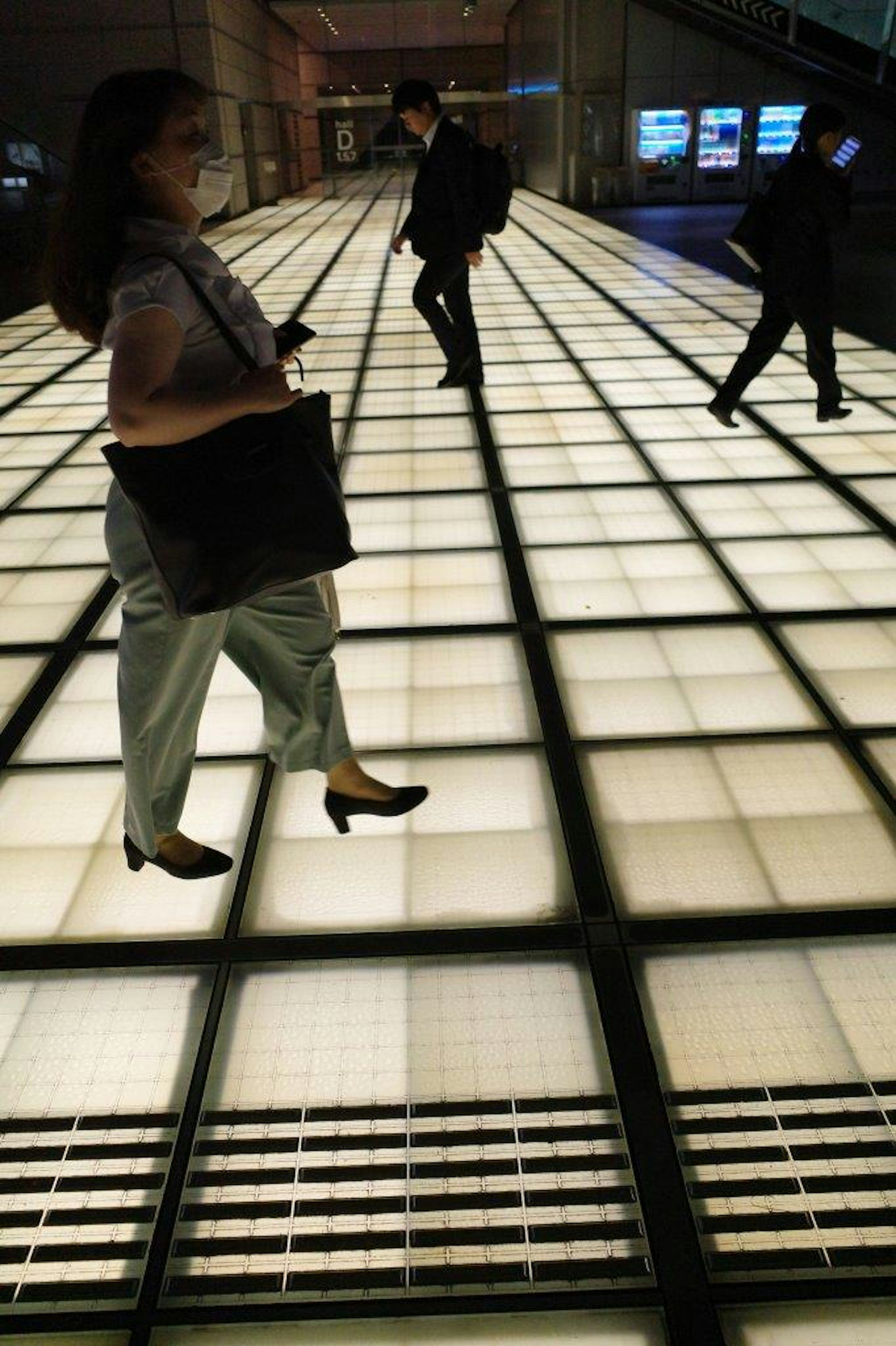 People walking on a bright, modern floor in an indoor space