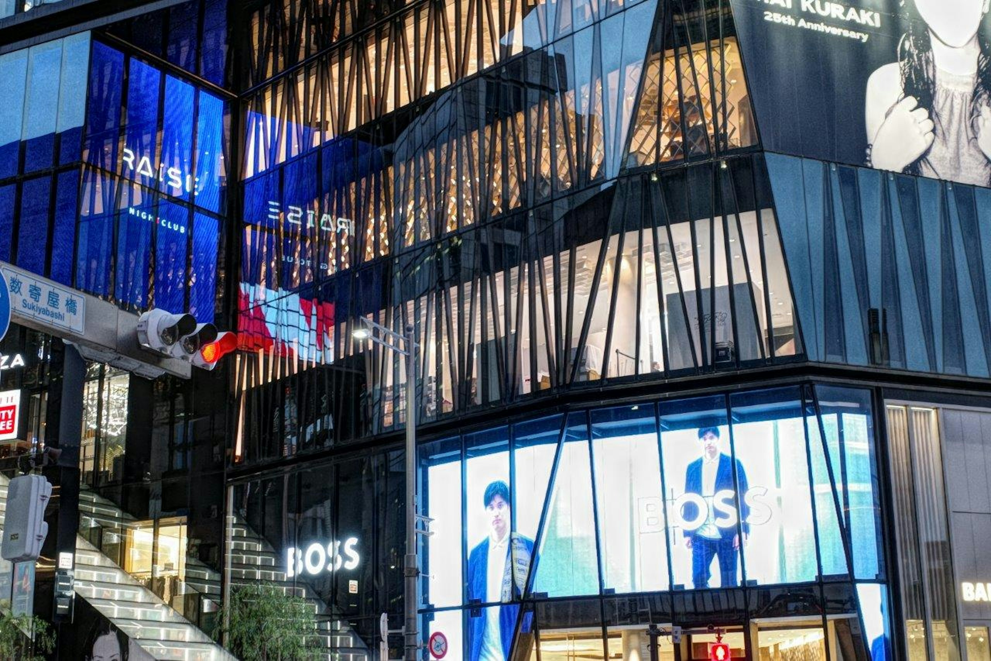 Fachada de edificio moderno con señalización de BOSS y reflejos de luz azul