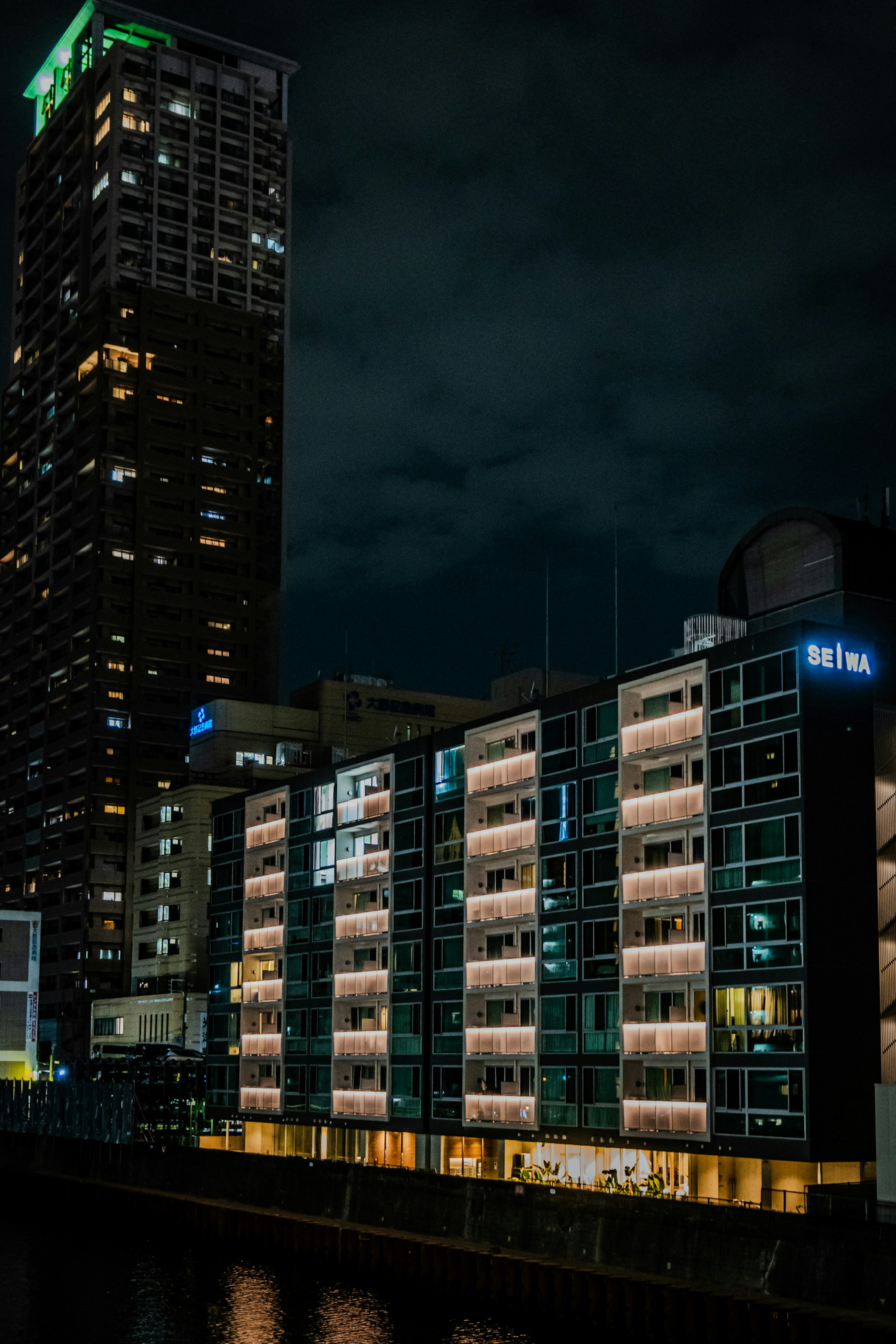 Kontras antara gedung tinggi dan apartemen rendah dalam pemandangan kota malam