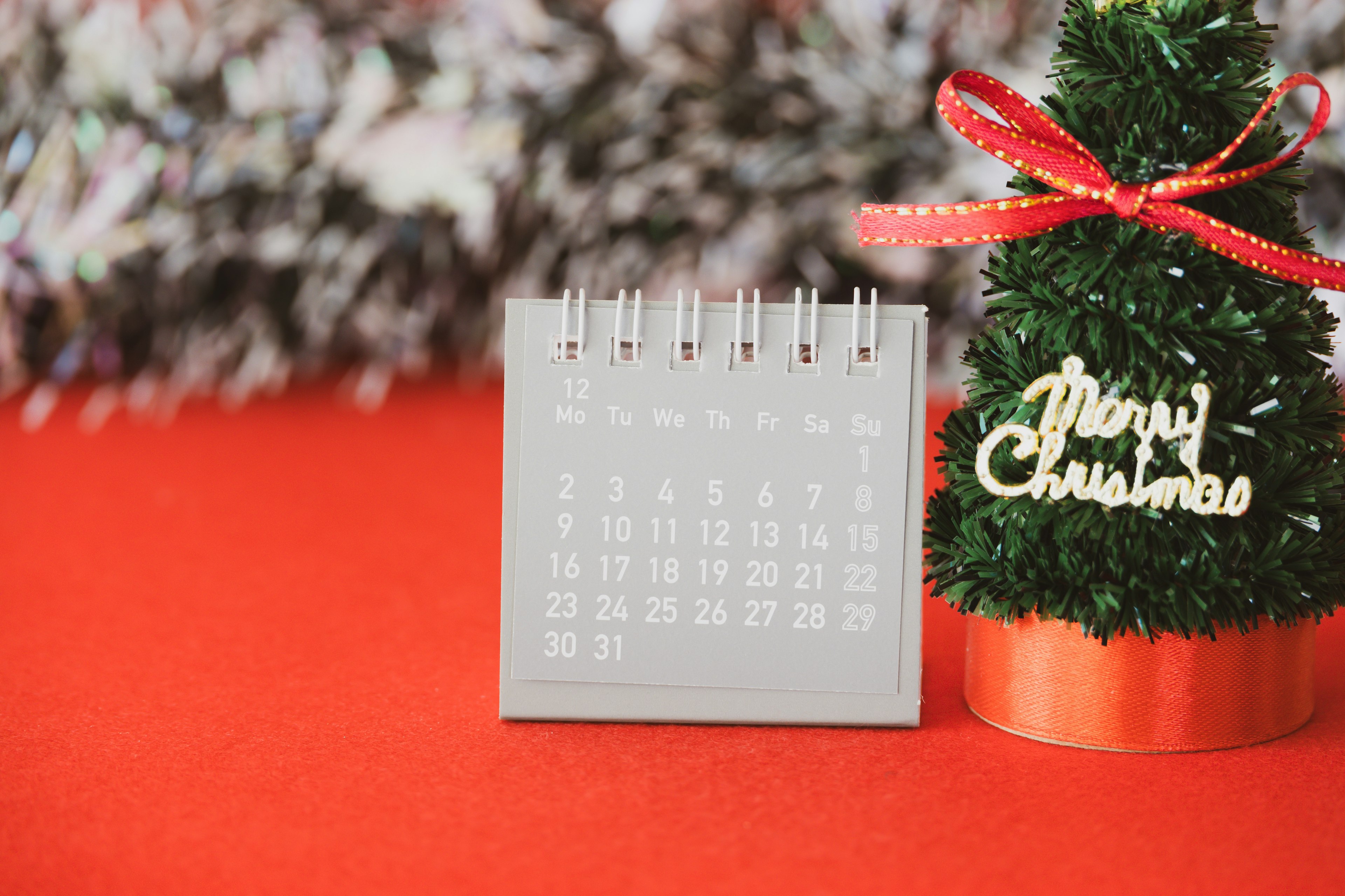 Imagen de un pequeño calendario y un árbol de Navidad con fondo rojo