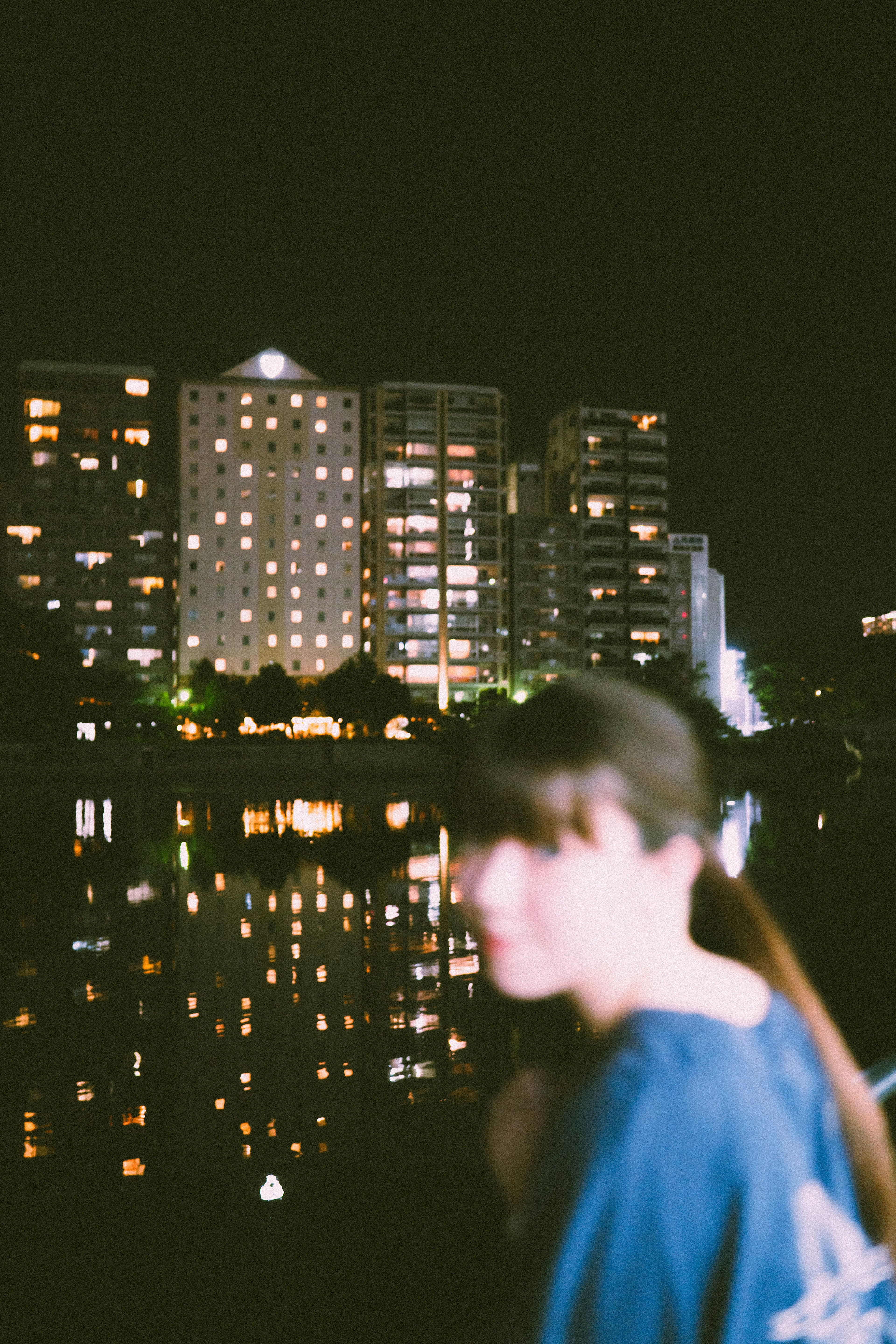 Blurred silhouette of a woman with a city skyline at night