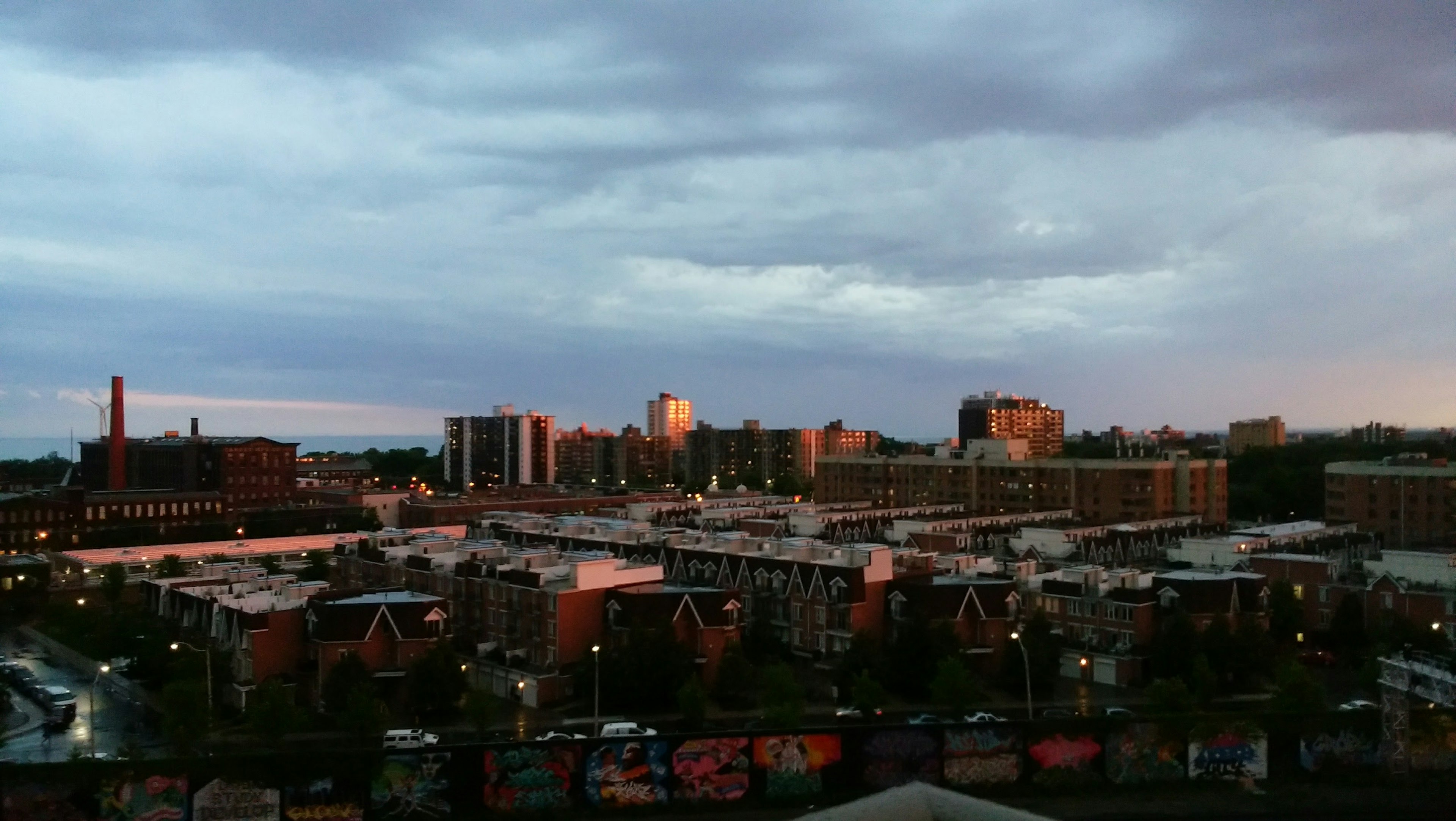 Paysage urbain au crépuscule avec des bâtiments de grande et de petite hauteur sous un ciel nuageux et une lumière douce