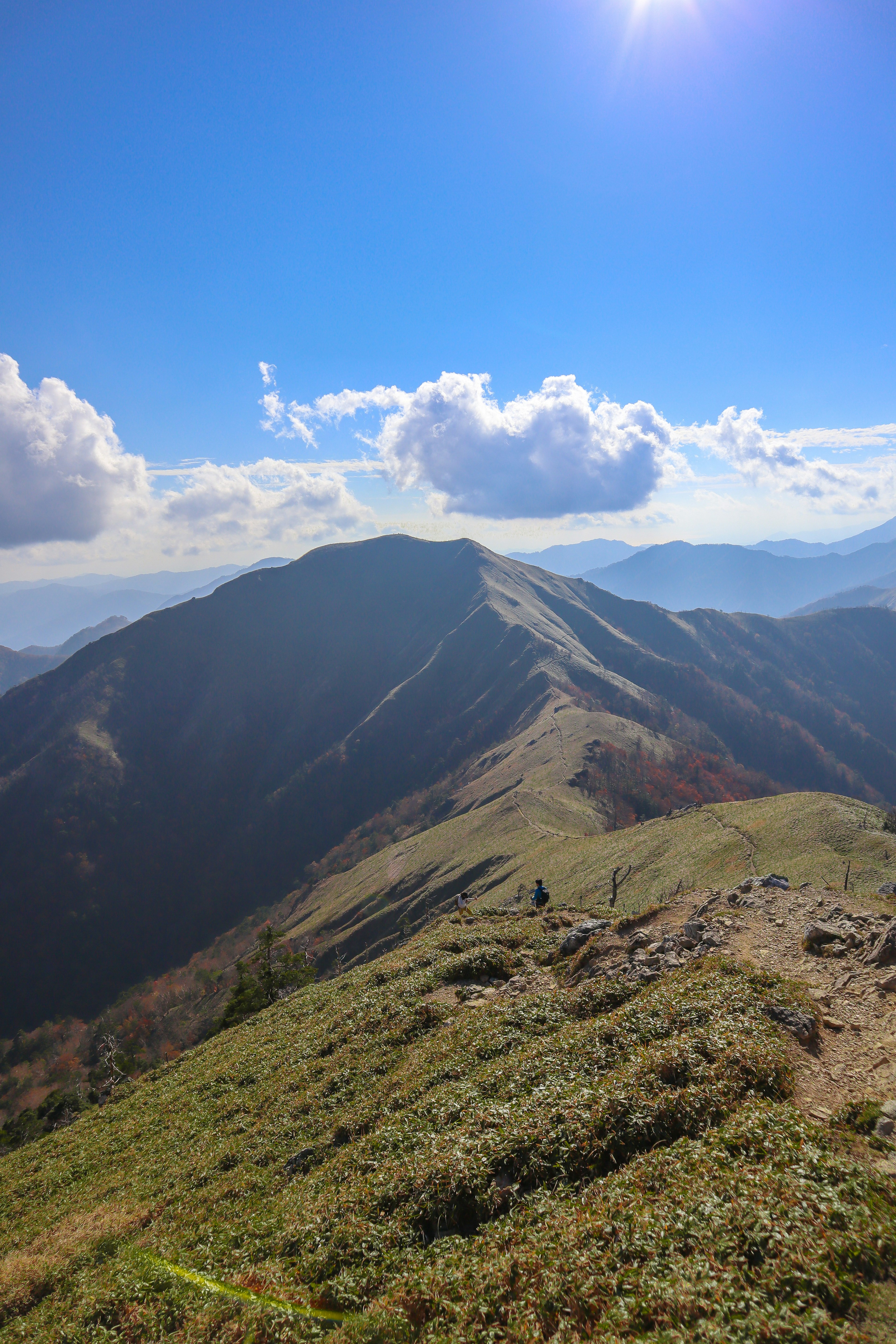 Paesaggio montano circondato da un cielo blu e nuvole Prato verde sulla cresta della montagna