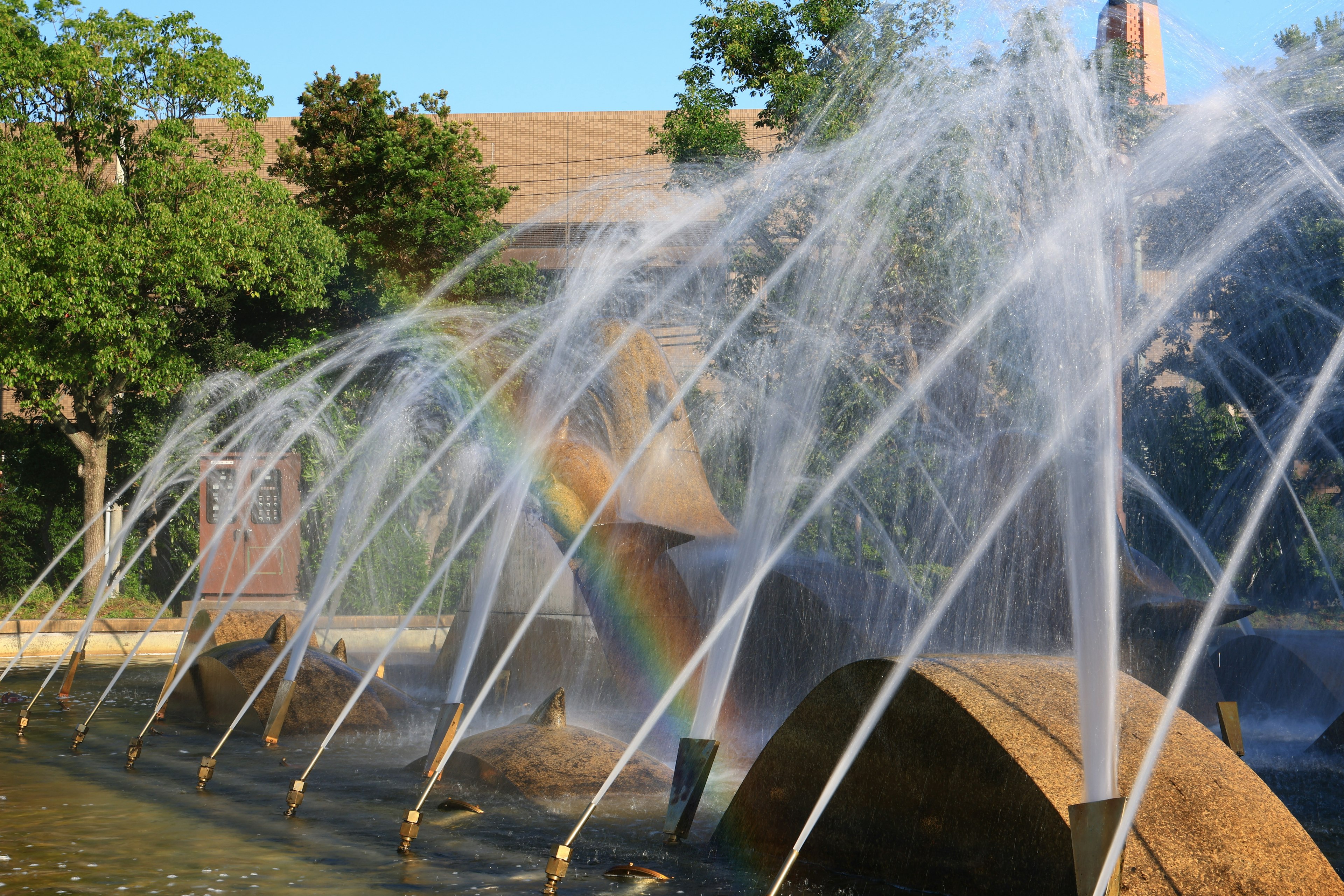 A fountain creating colorful water sprays with a rainbow