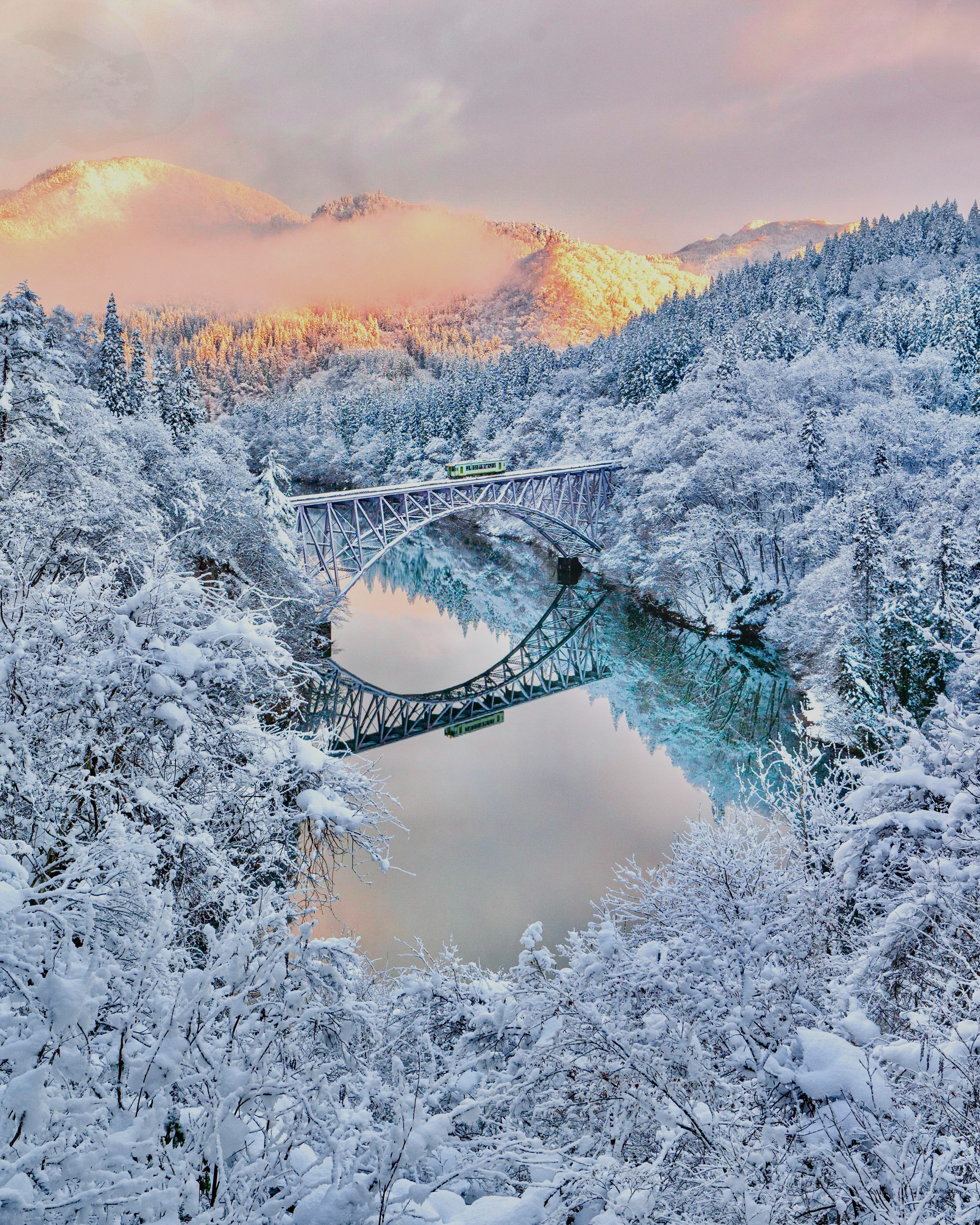 สะพานสวยงามเหนือภูมิทัศน์ที่ปกคลุมไปด้วยหิมะและแม่น้ำที่เงียบสงบ