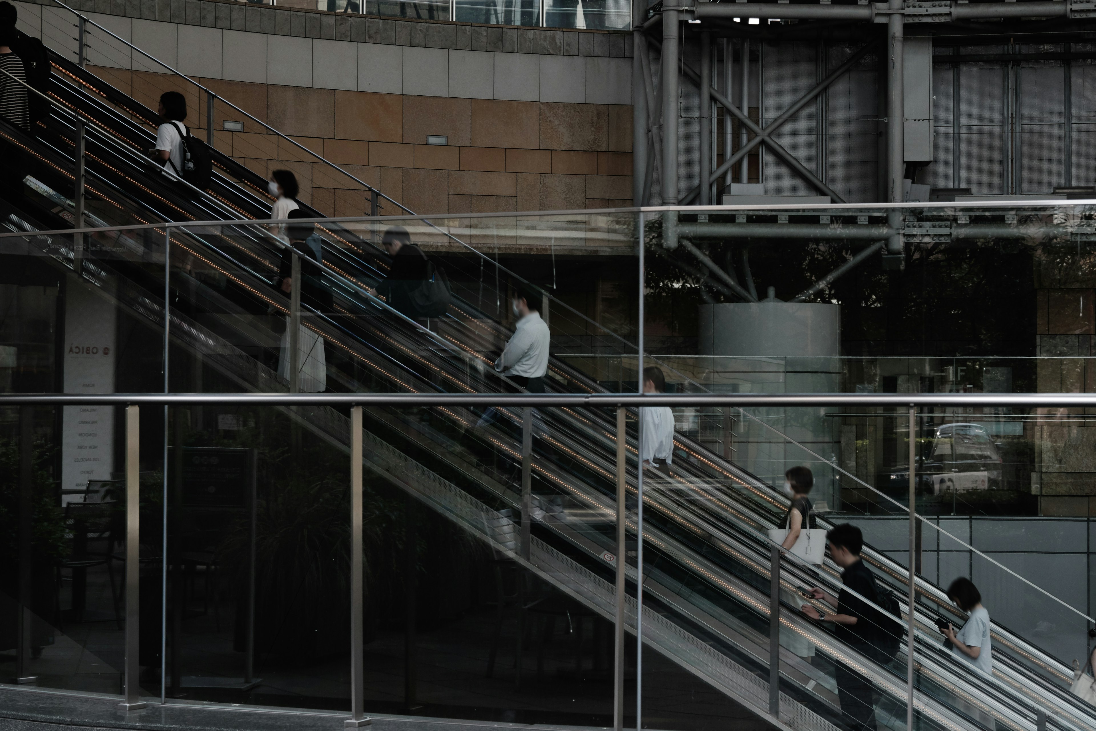 People descending an escalator in a modern building