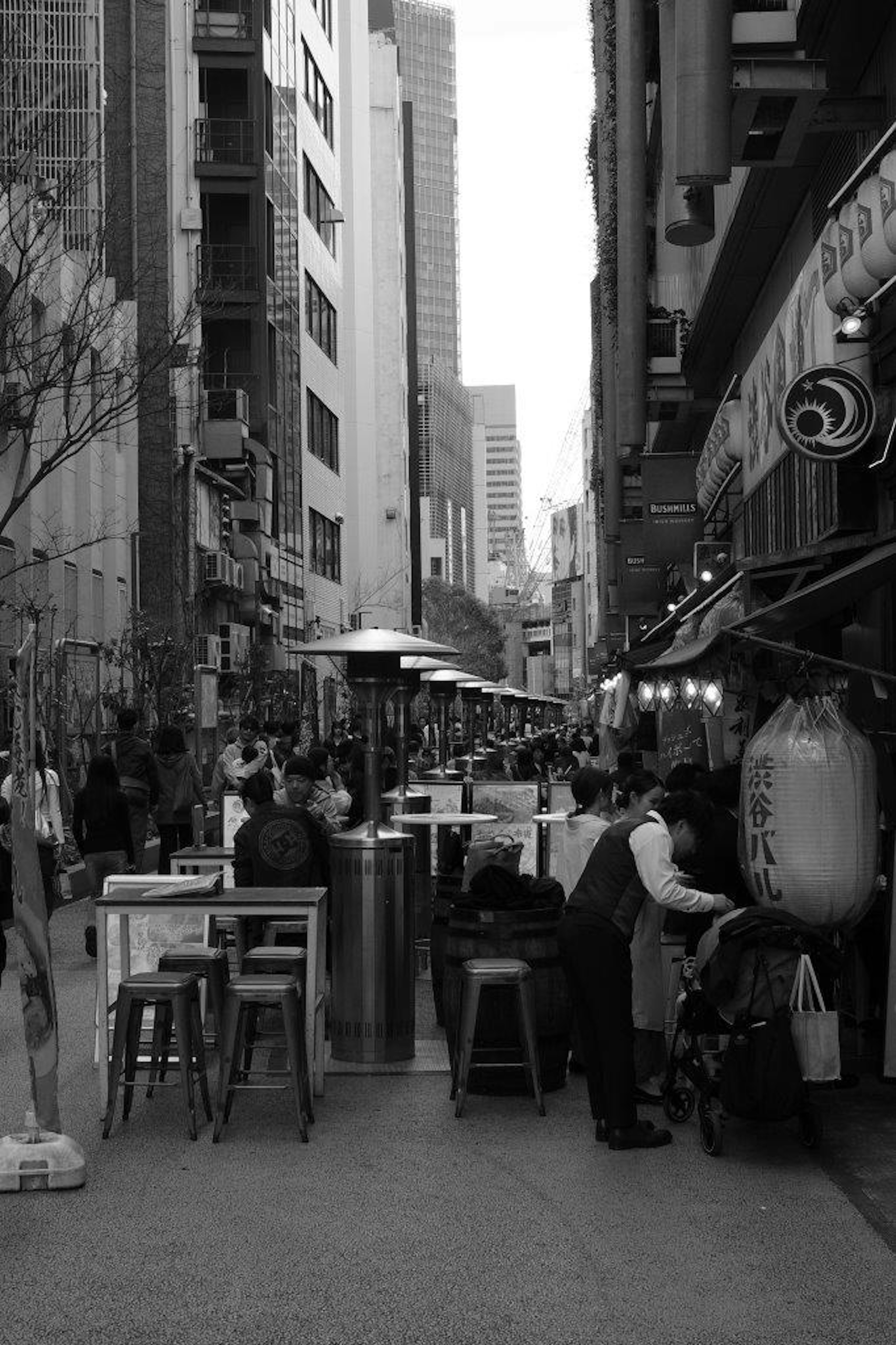 Foto en blanco y negro de una calle llena de cafés y restaurantes