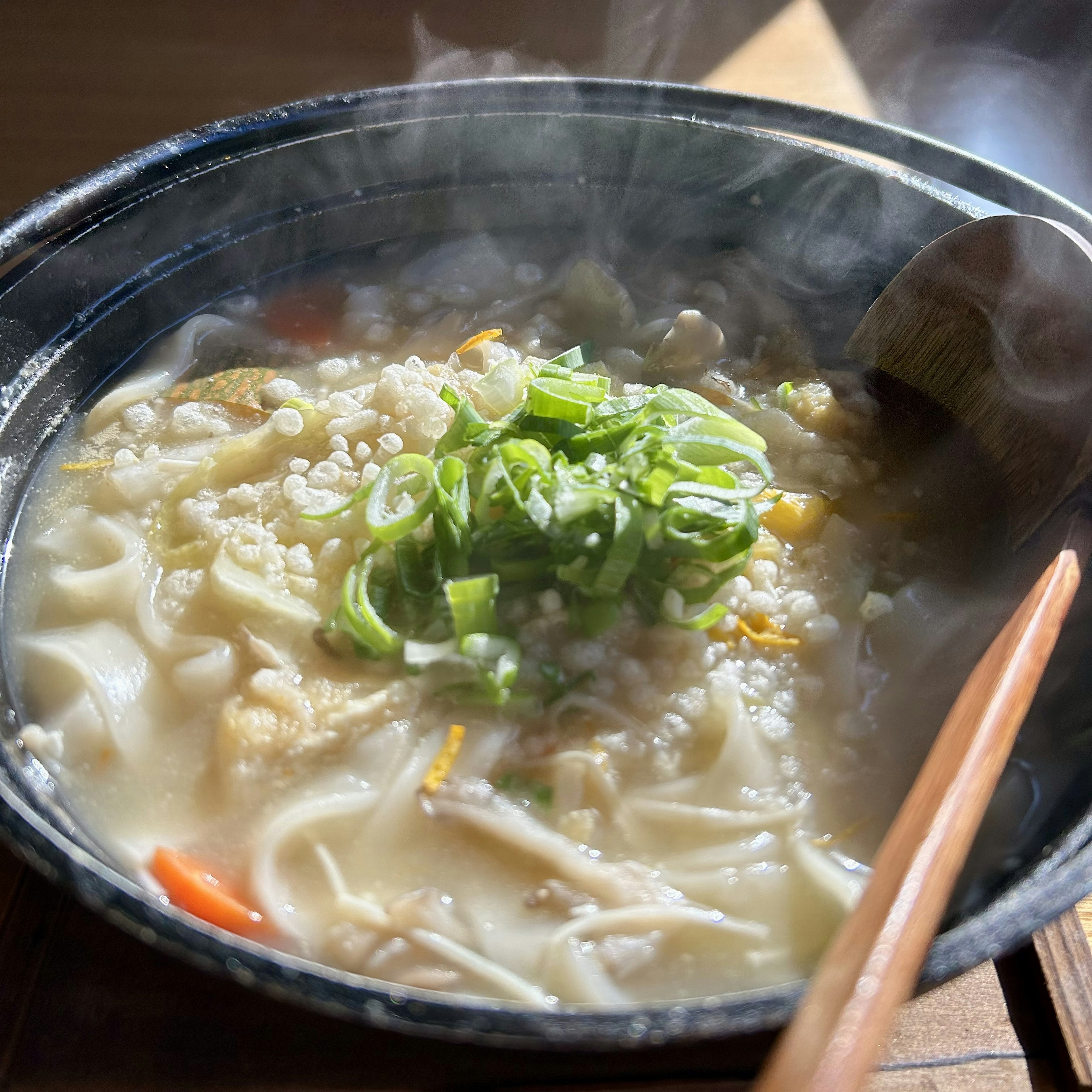 Sup panas dengan mie udon dan taburan daun bawang