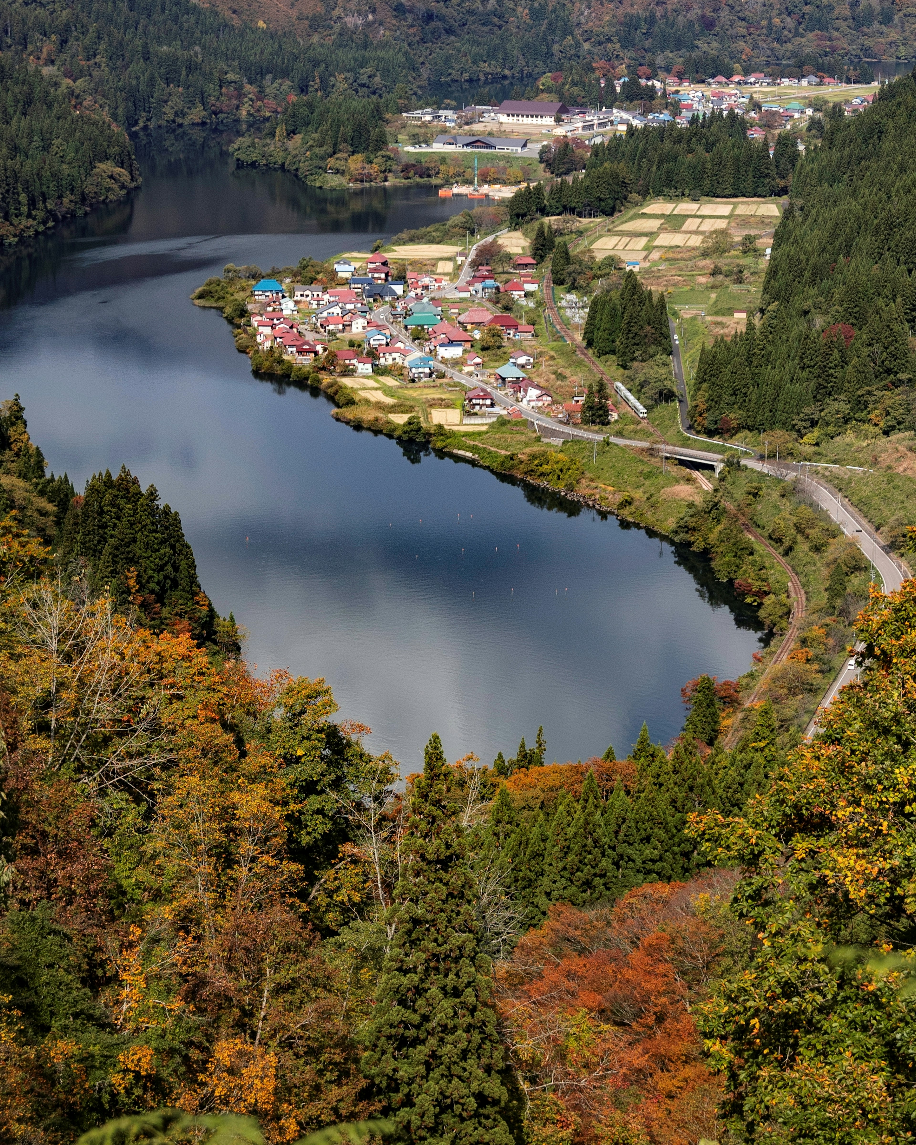 美しい秋の風景に囲まれた静かな湖と小さな村