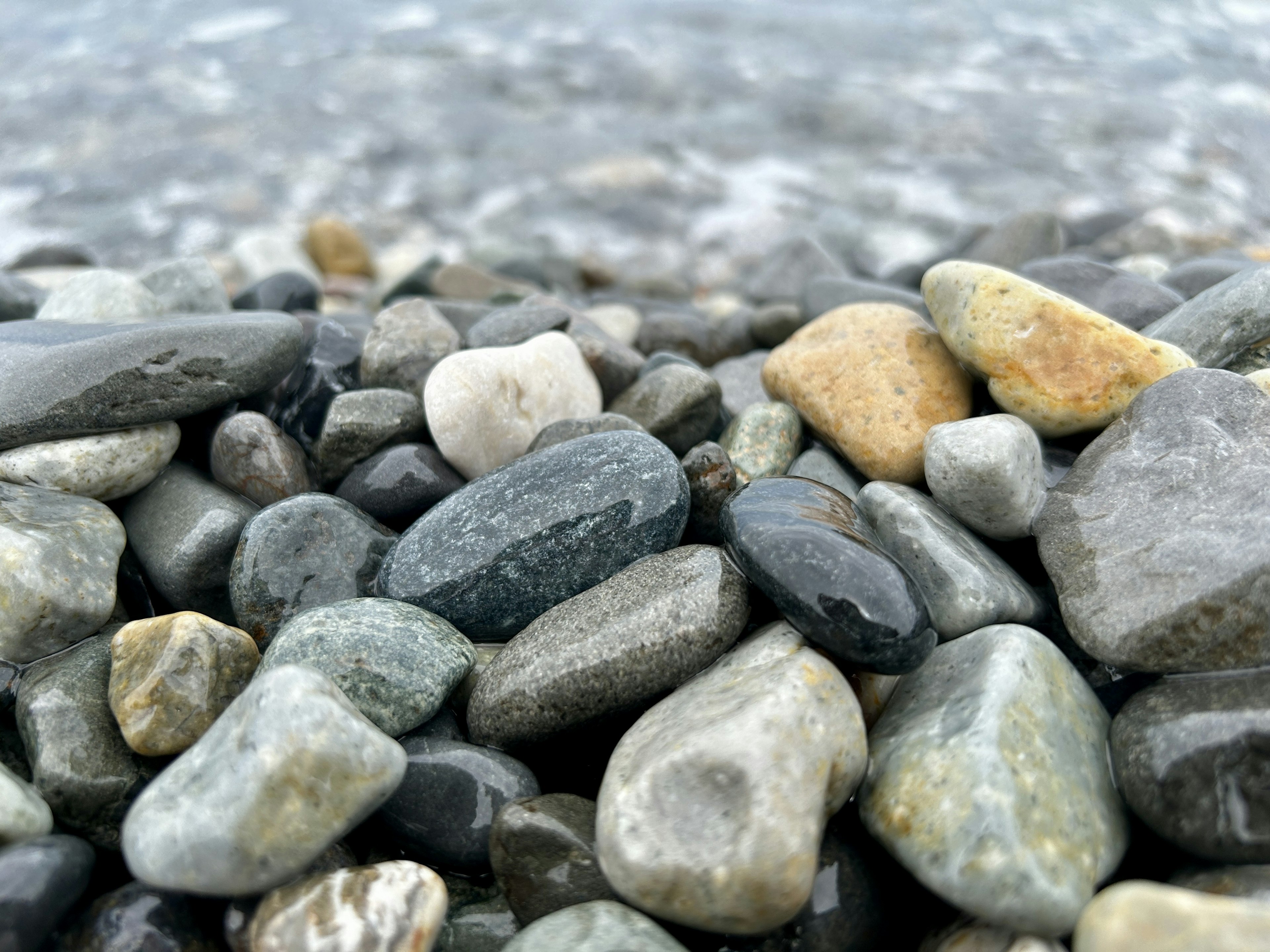 Gambar close-up berbagai batu berwarna di pantai