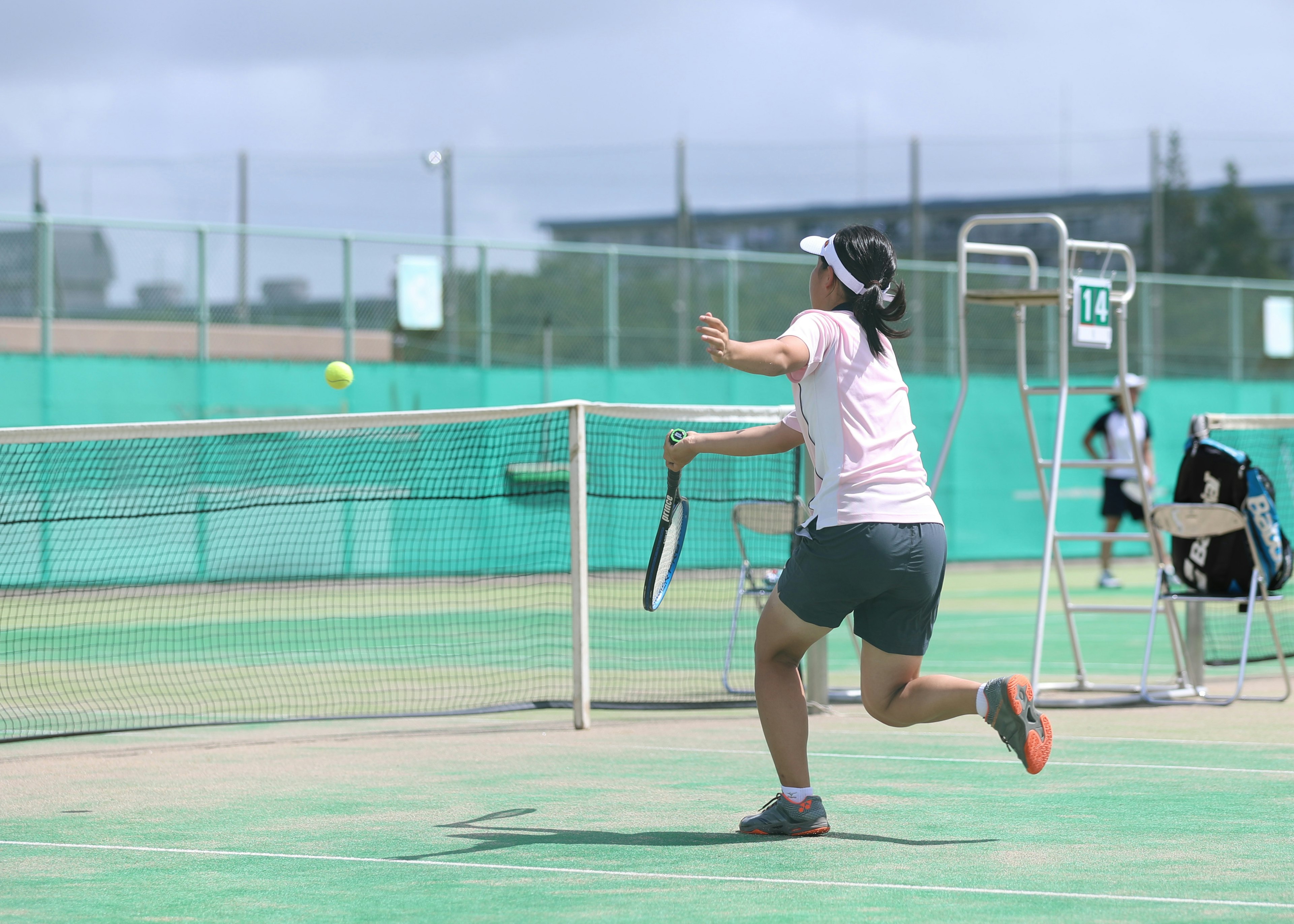 Jugadora golpeando una pelota de tenis en una cancha