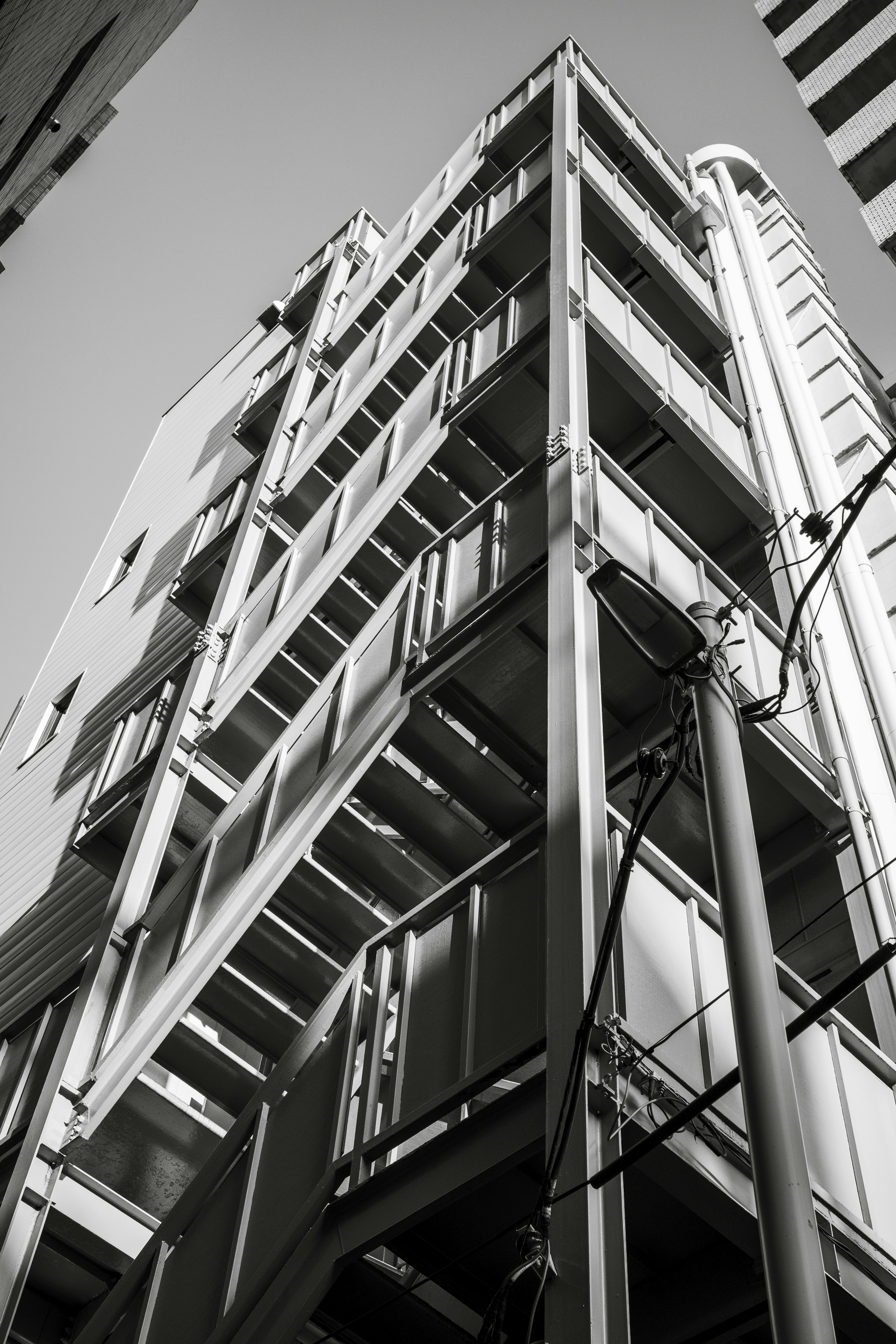 Monochrome image showing a high-rise building from a low angle highlighting its structure