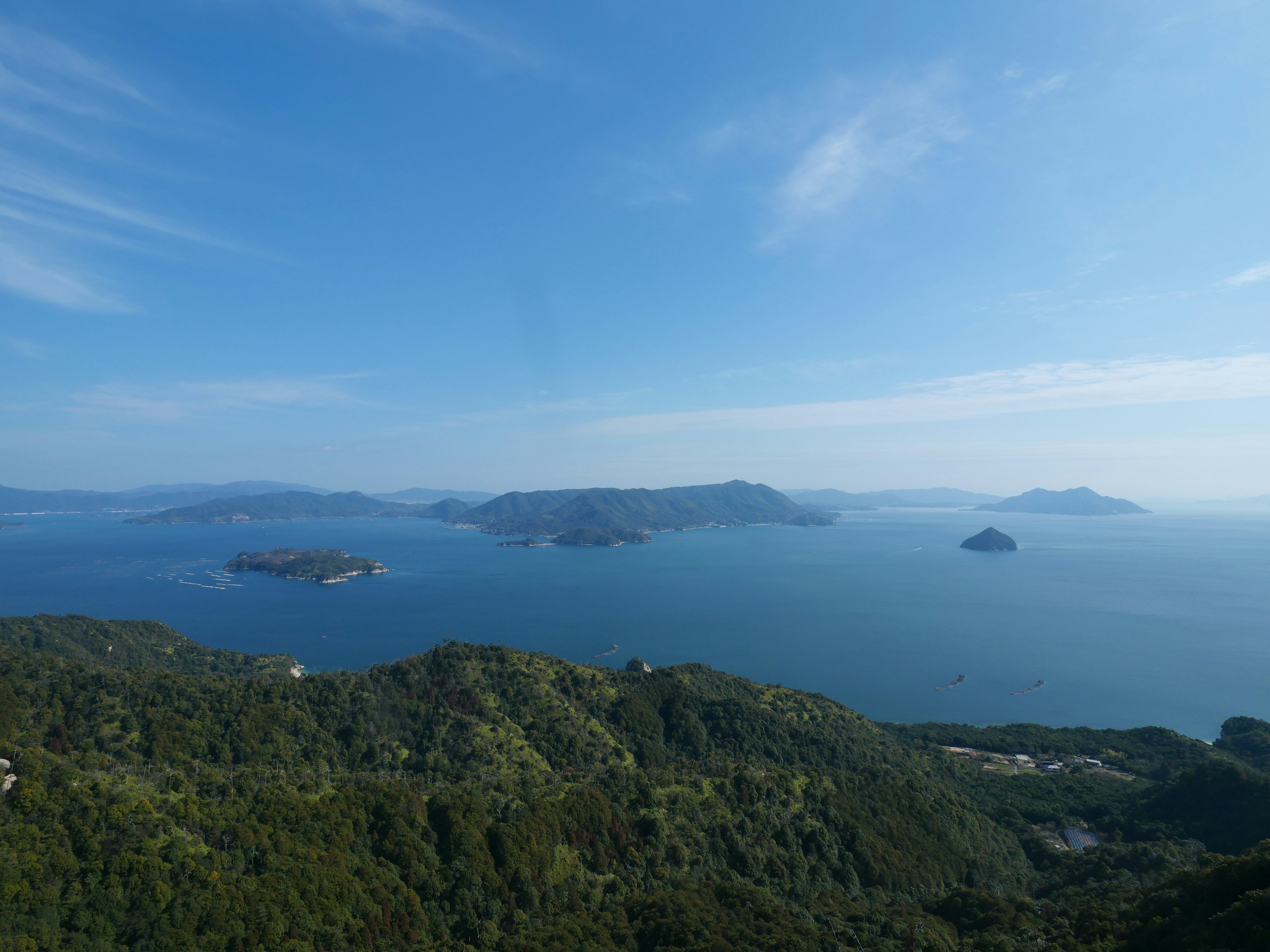 Pemandangan laut biru dan gunung hijau beberapa pulau di kejauhan