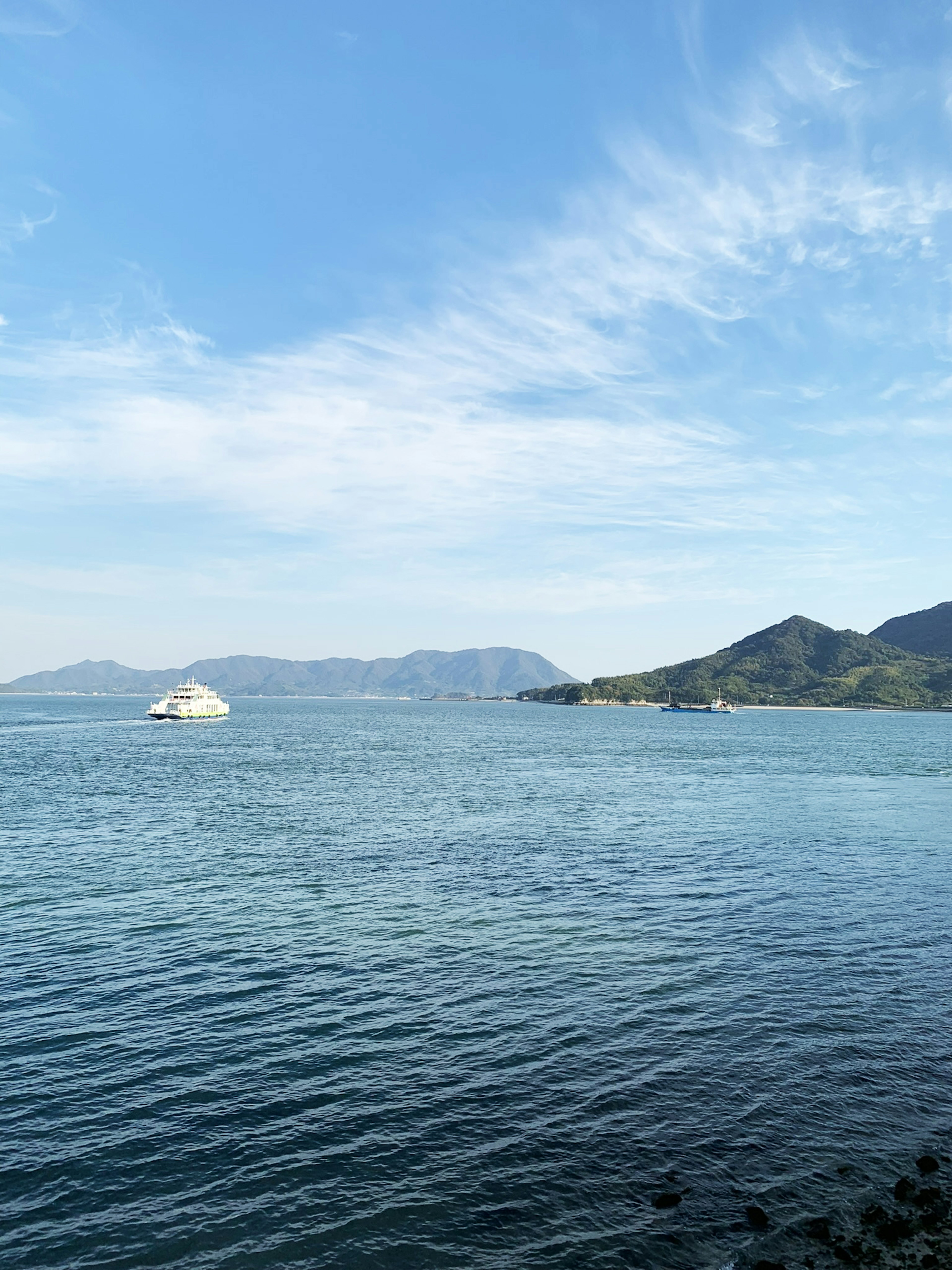 Landschaft mit blauem Meer und Himmel sowie einem kleinen Boot