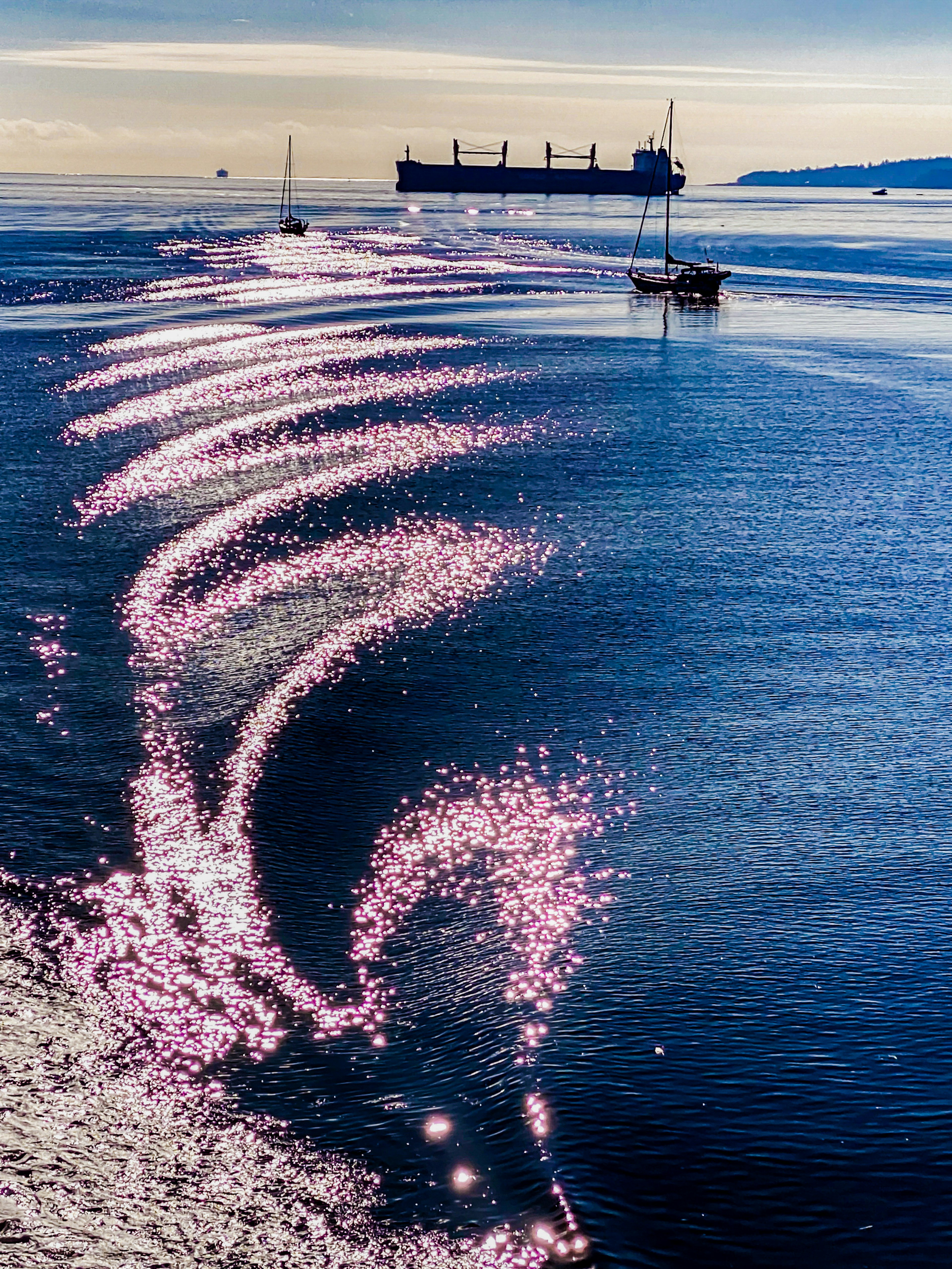 Hermoso paisaje de ondas oceánicas y reflejos de luz con una estela de barco en el agua