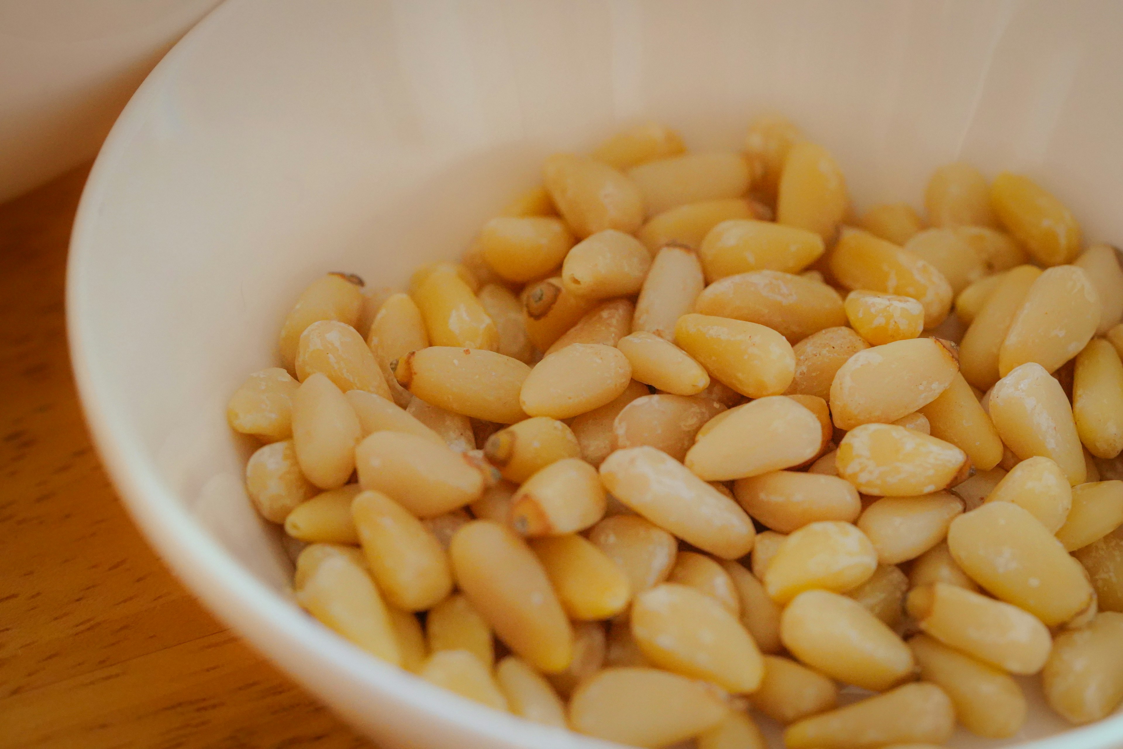 Pine nuts displayed in a white bowl