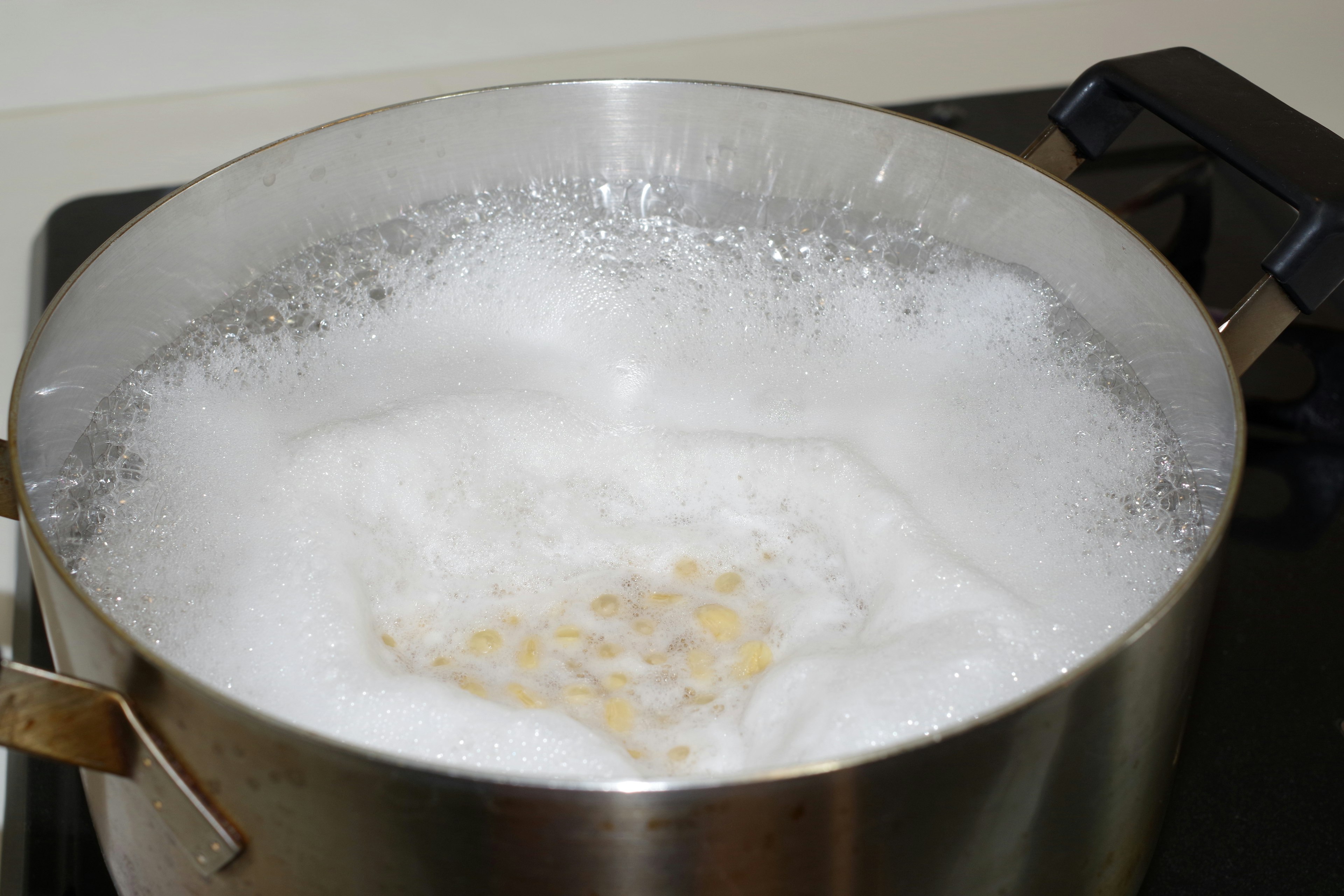 鍋で沸騰している泡立った水と穀物の様子