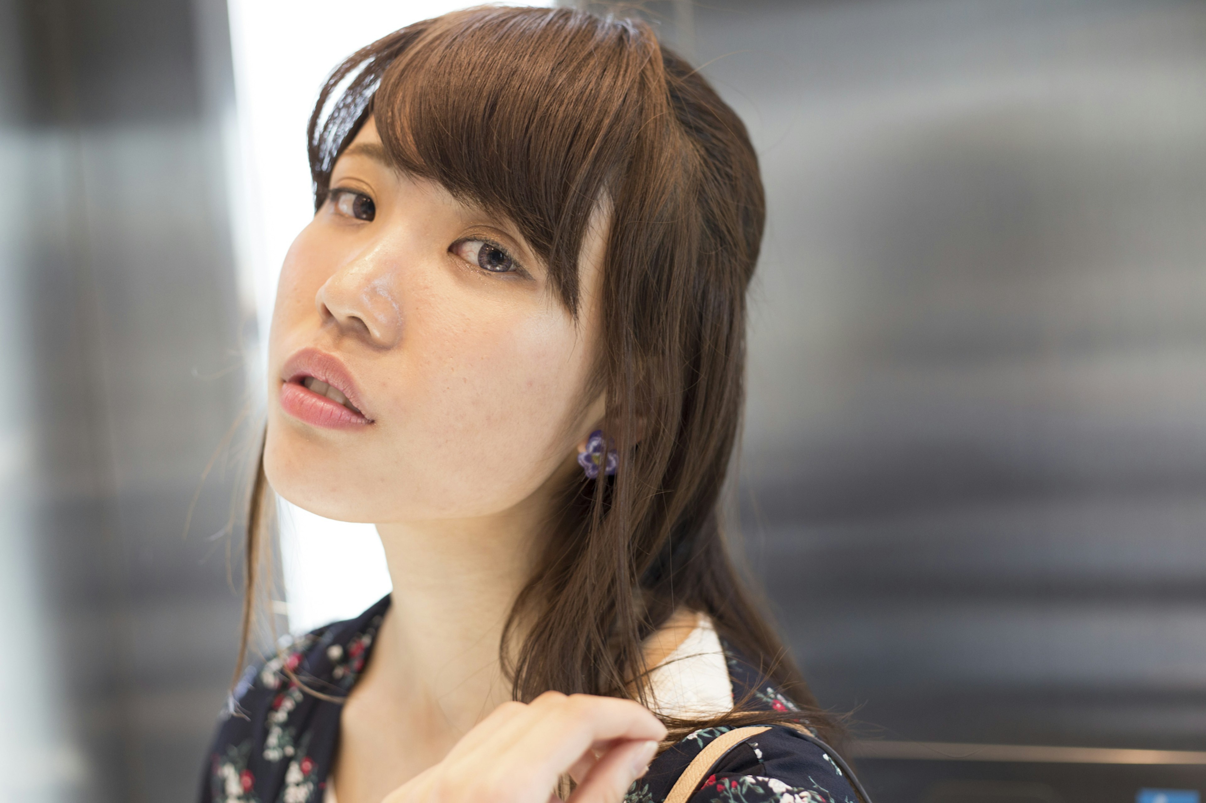 Portrait of a woman looking at the camera Brown hair cascading over her shoulder Wearing purple earrings