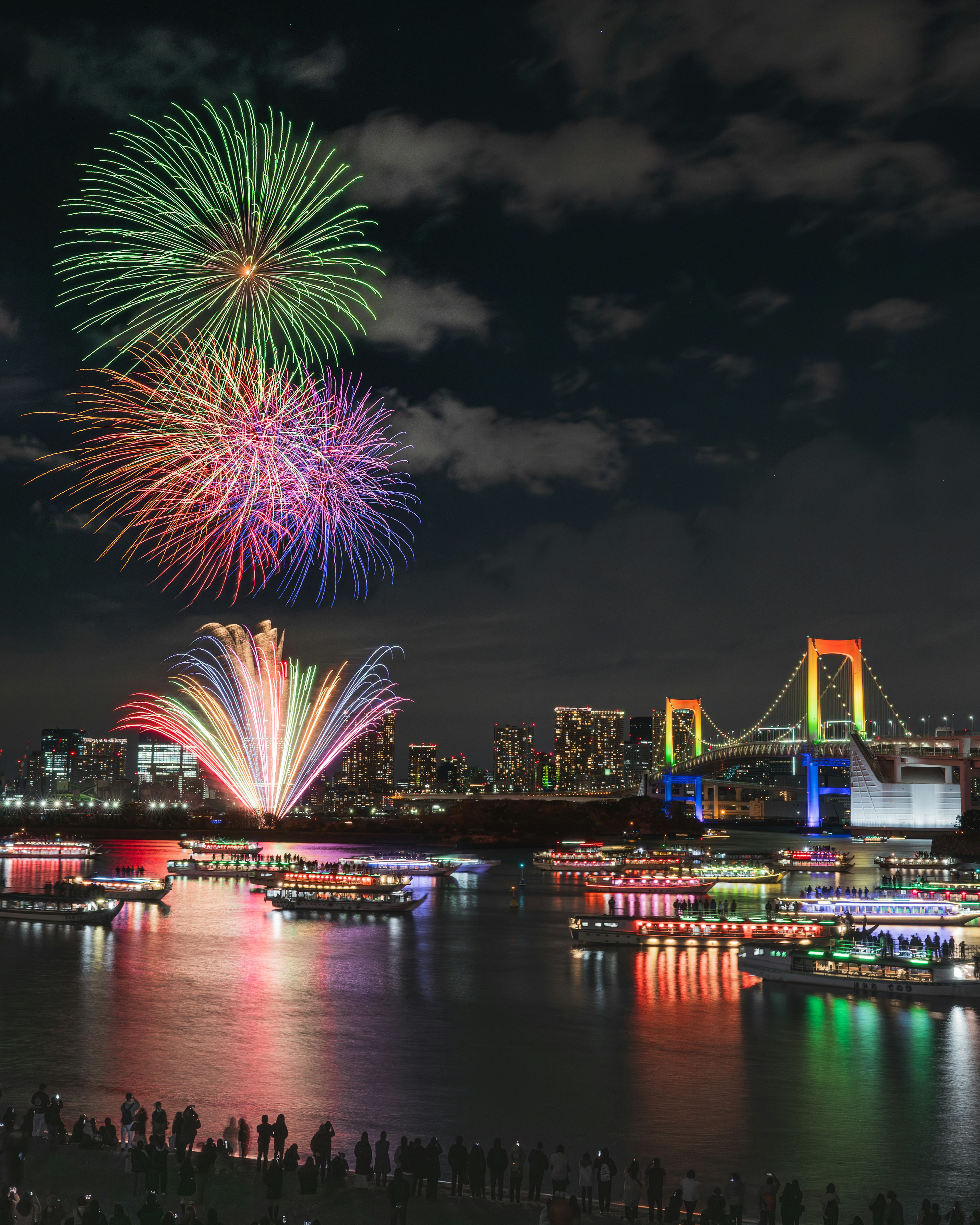 夜空に咲く色とりどりの花火と美しいレインボーブリッジ